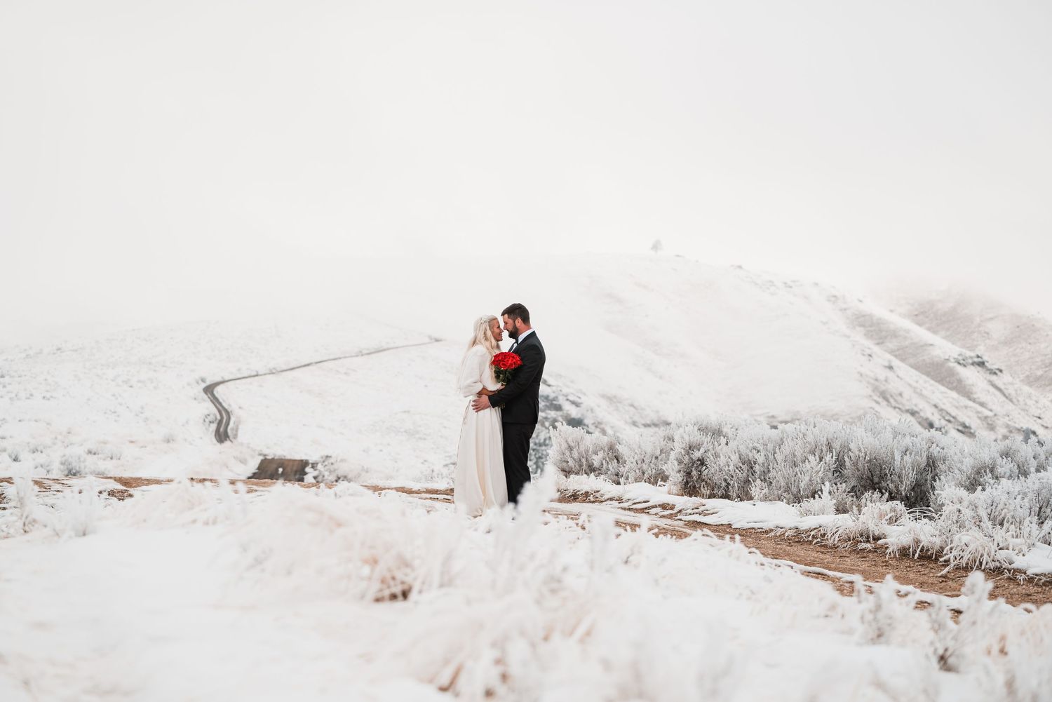 A snowy winter mountain landscape provides backdrop for a romantic moment.