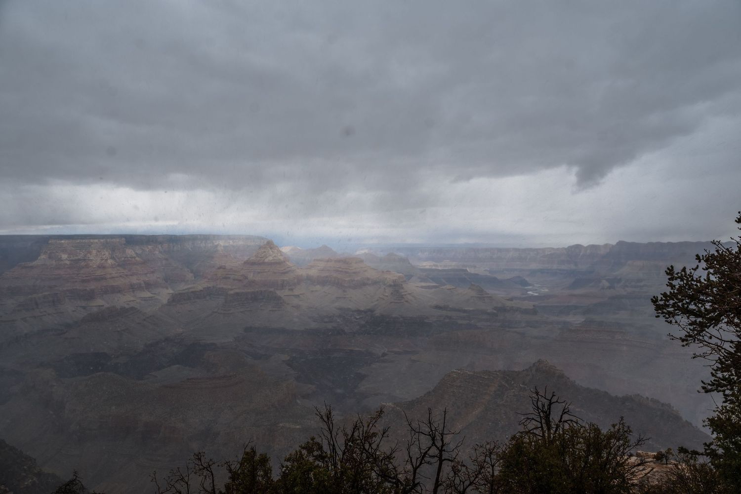 Storm clouds gather over the vast Grand Canyon landscape creating a moody atmosphere.