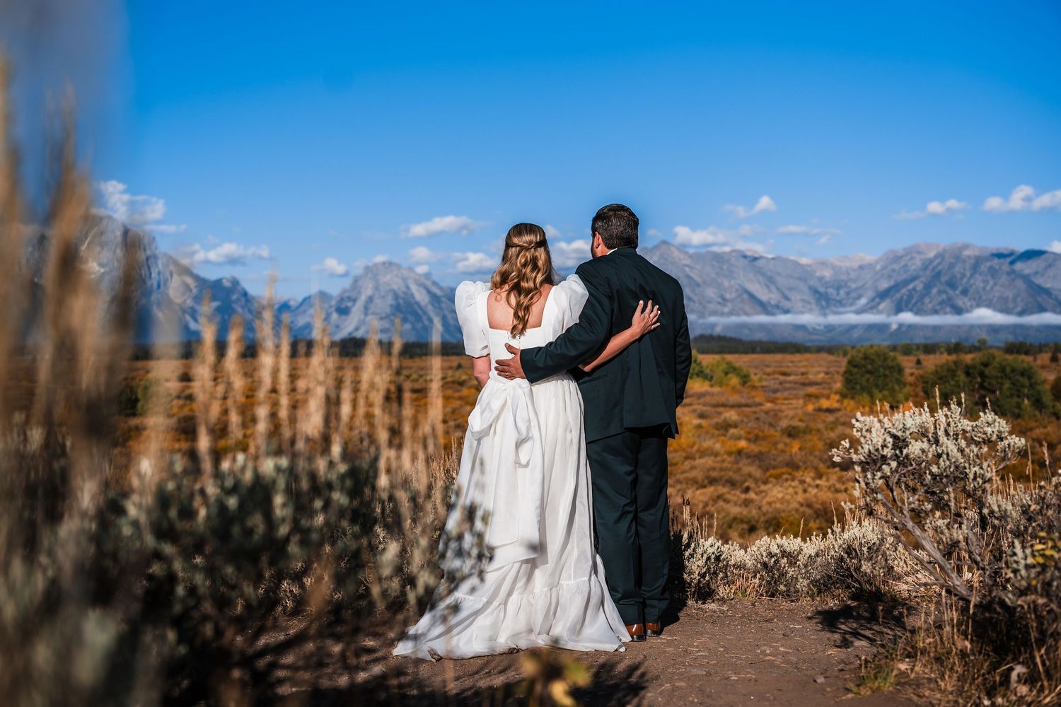 Couple shares intimate moments against dramatic mountain landscapes during their wedding.