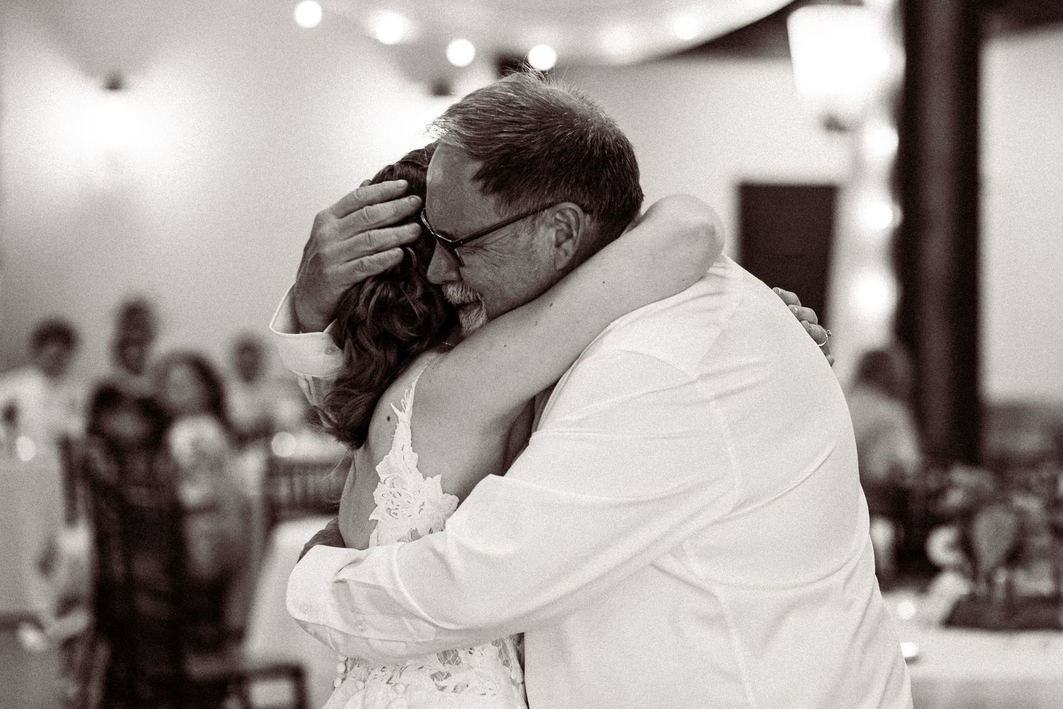 Black and white photo of bride sharing an emotional dance with her father.