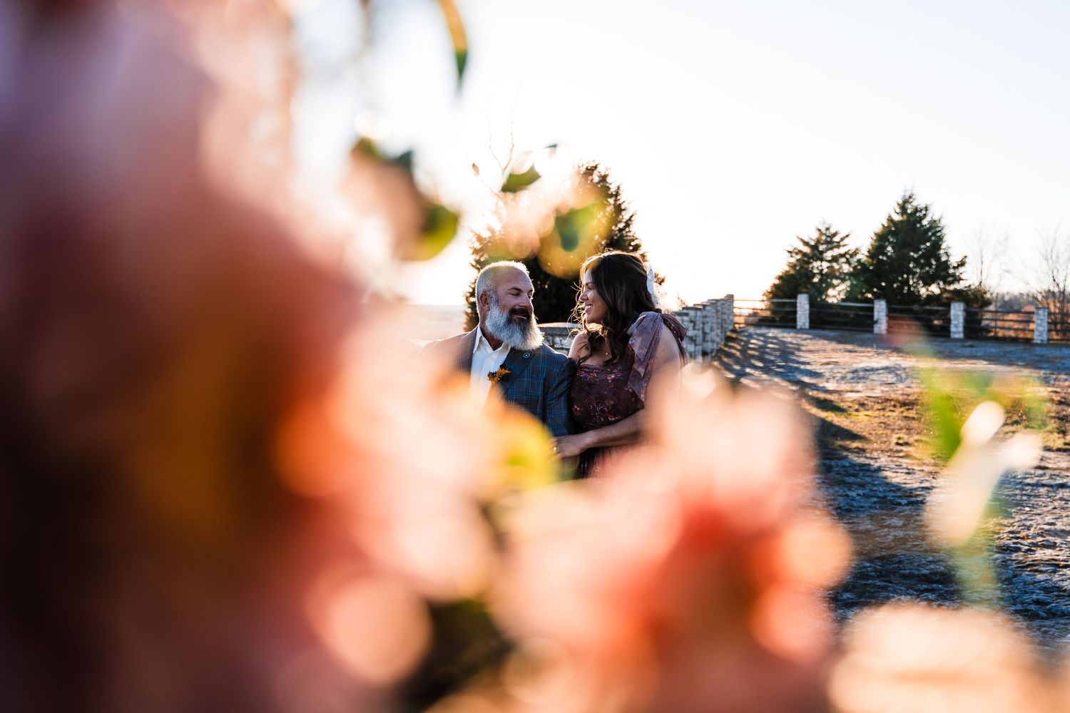 Artistic photo through sunflowers showing blurred figures in background.