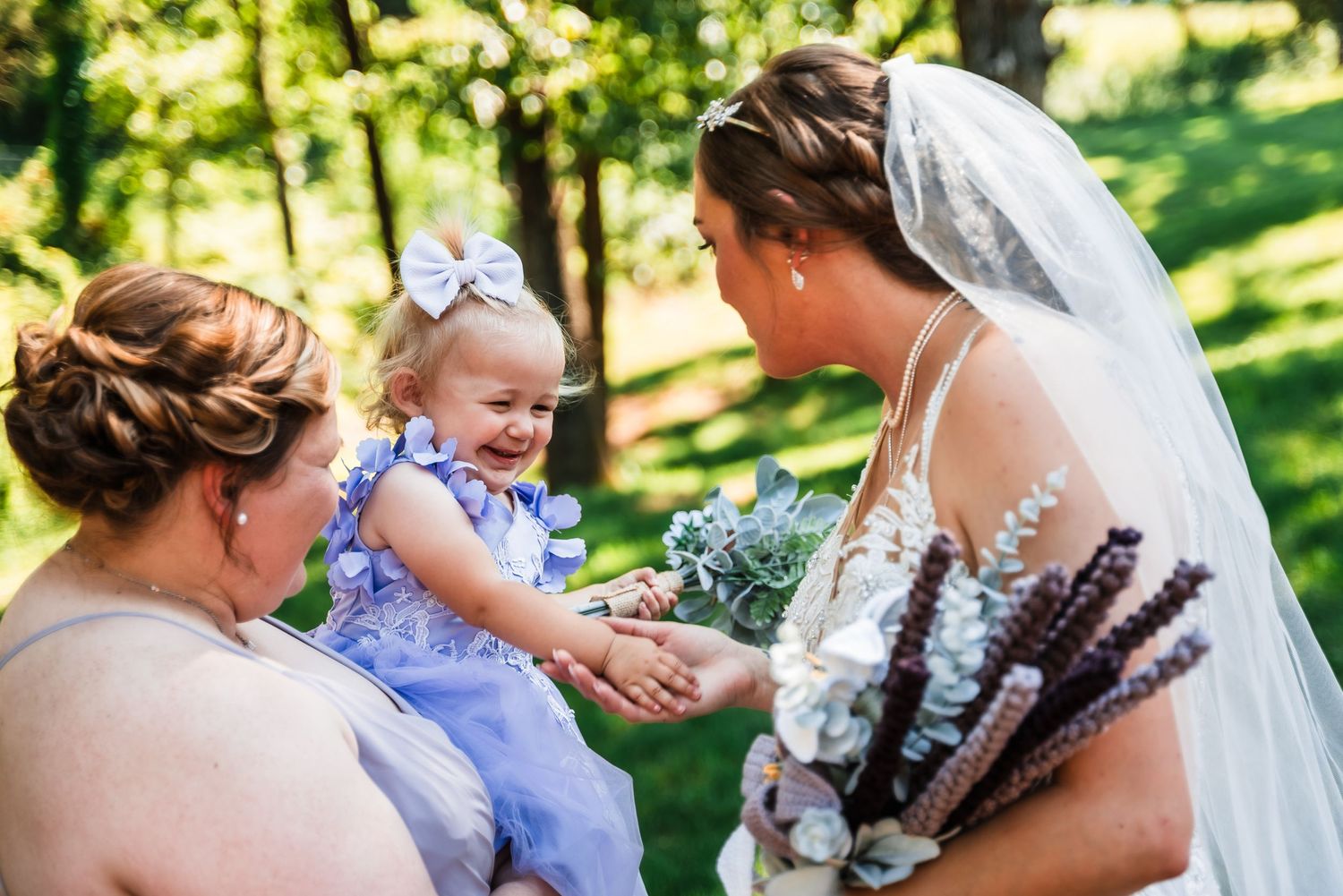 An outdoor wedding moment in a lush green garden setting with a bride wearing a lace gown.