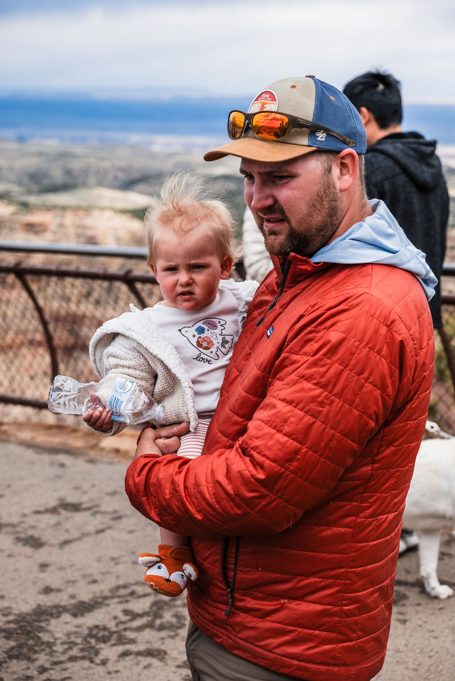 Visitors enjoying a scenic overlook at the Grand Canyon on a cloudy day.