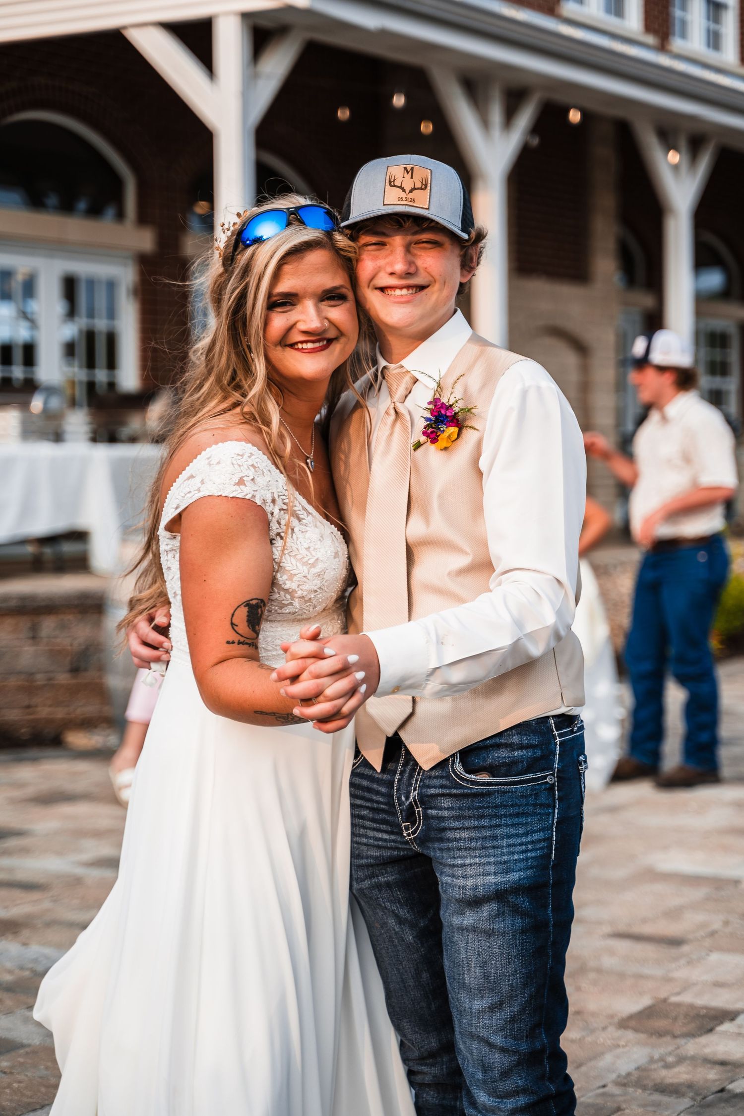 A casual country wedding couple posing together on a stone patio.