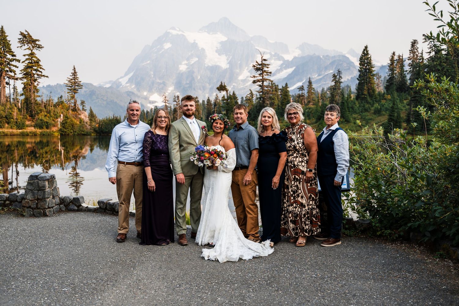 Wedding guests pose for group photos with dramatic mountain scenery in the background.