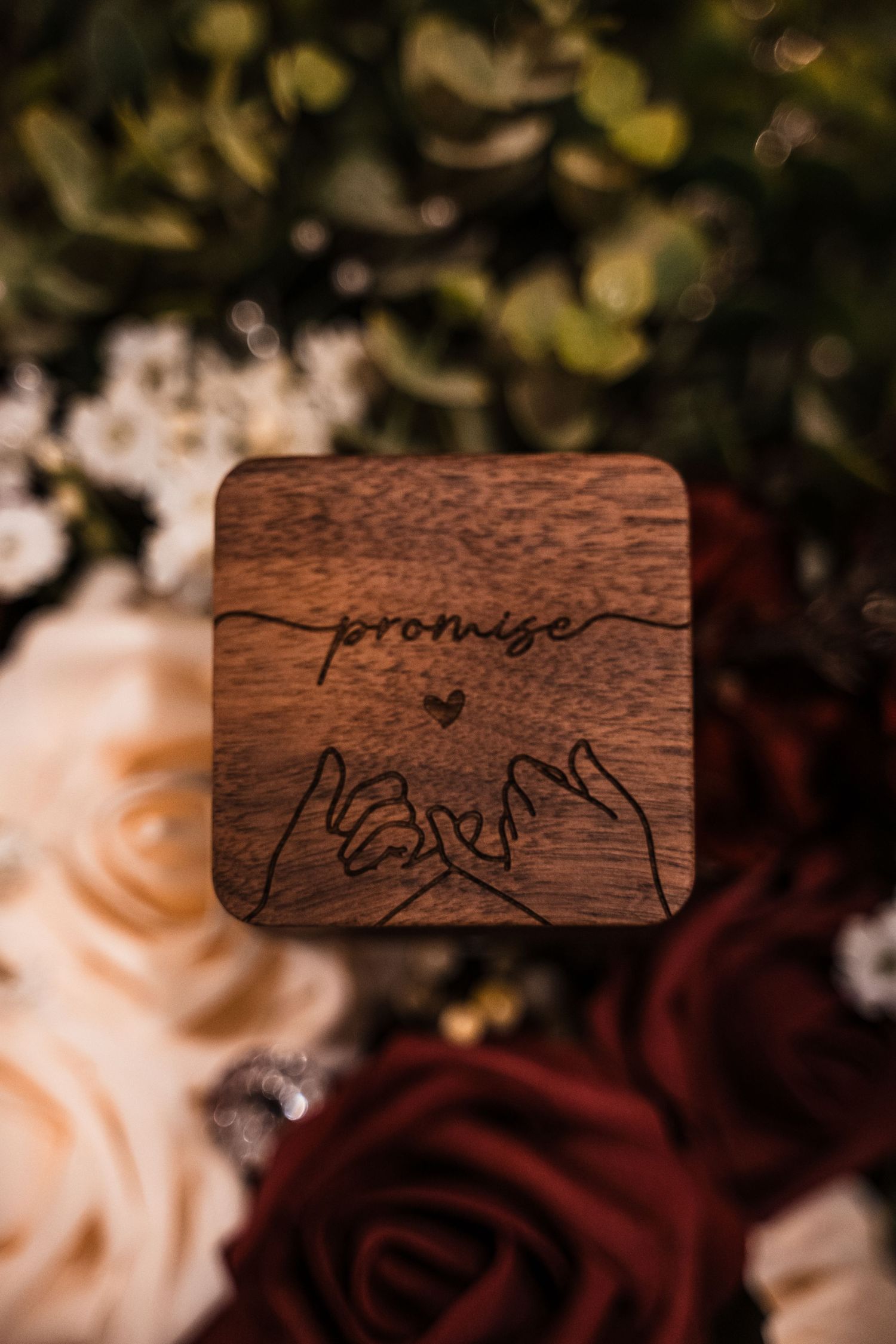 Wooden ring box with 'promise' text and hand-drawn pinky promise design surrounded by roses.