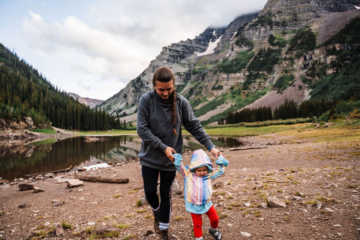 A peaceful moment by a mountain lake with gentle guidance on a rocky shore.