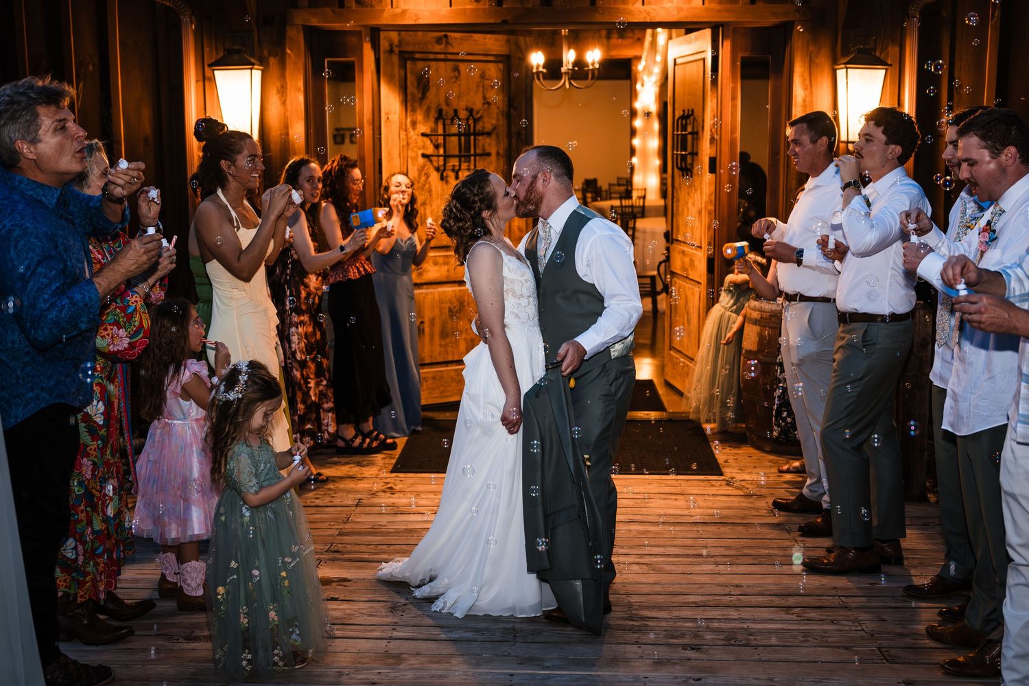 Bride and groom sharing a first dance kiss at their rustic indoor wedding reception.