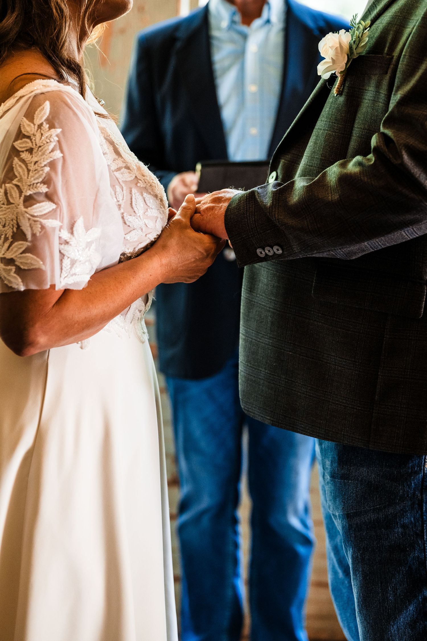 Detail shot of formal attire during what appears to be a wedding ceremony moment.