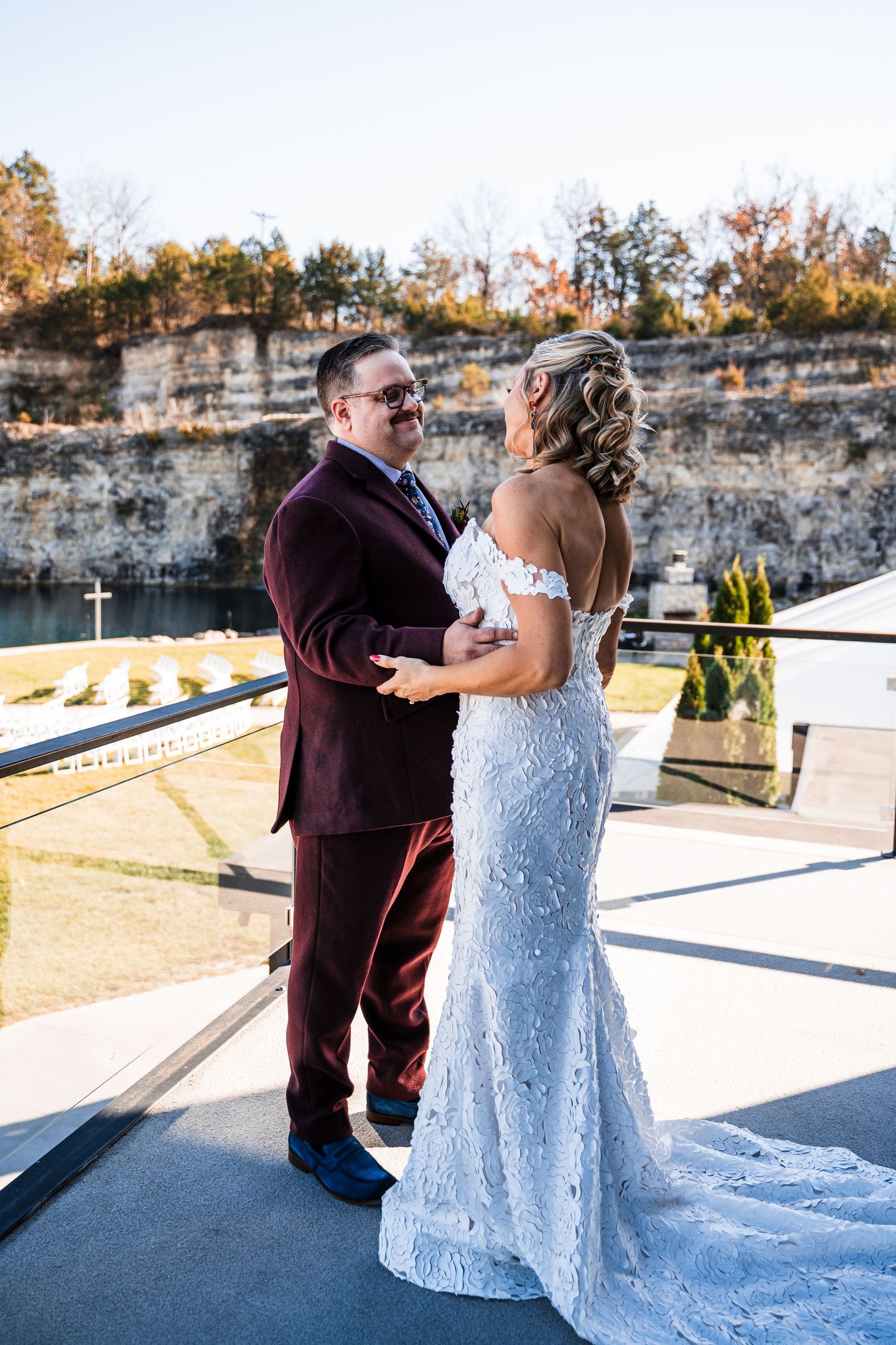 A romantic first look sequence between a couple on their wedding day, captured against a stone wall backdrop.
