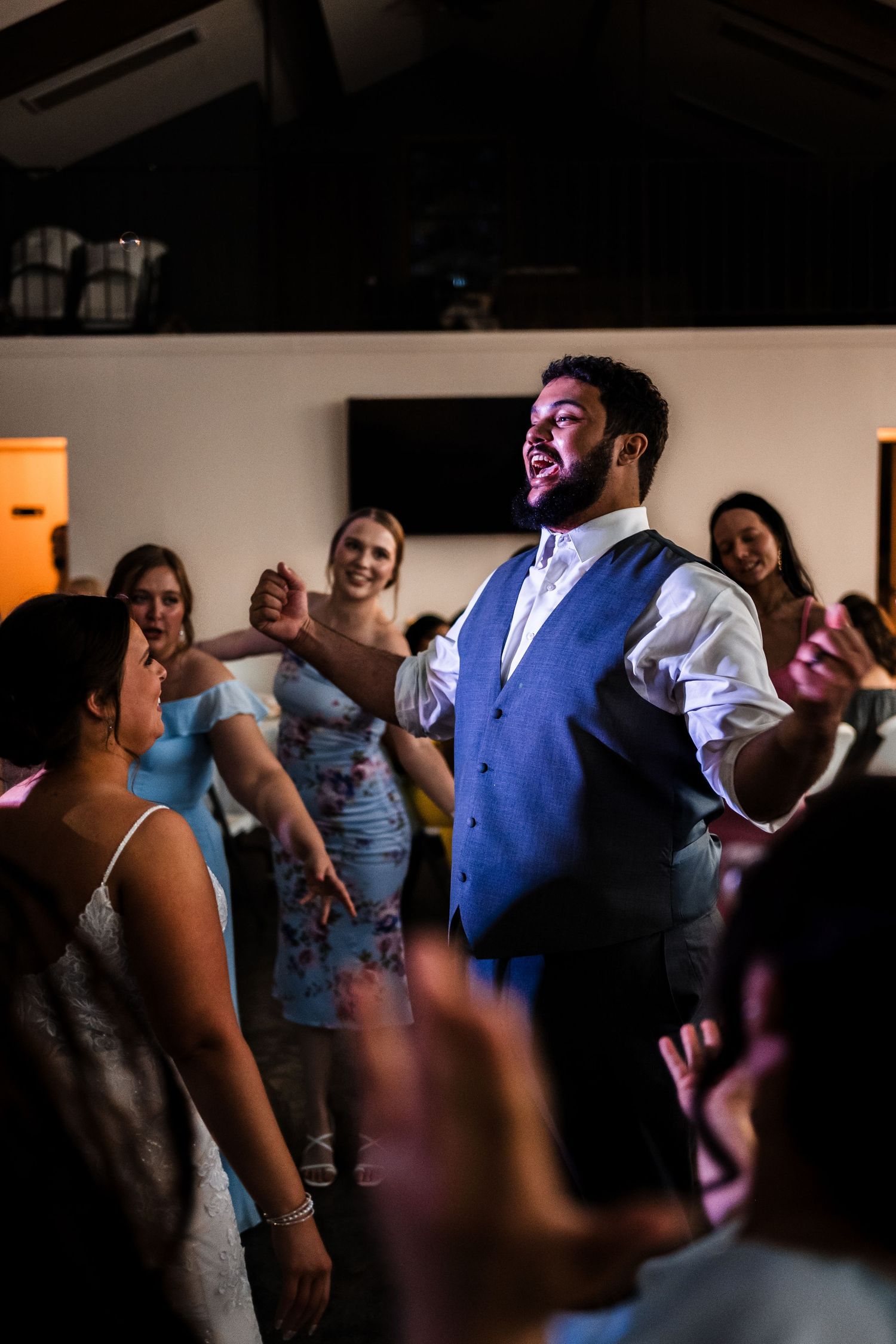 Wedding guests dancing and enjoying themselves during an indoor reception party.