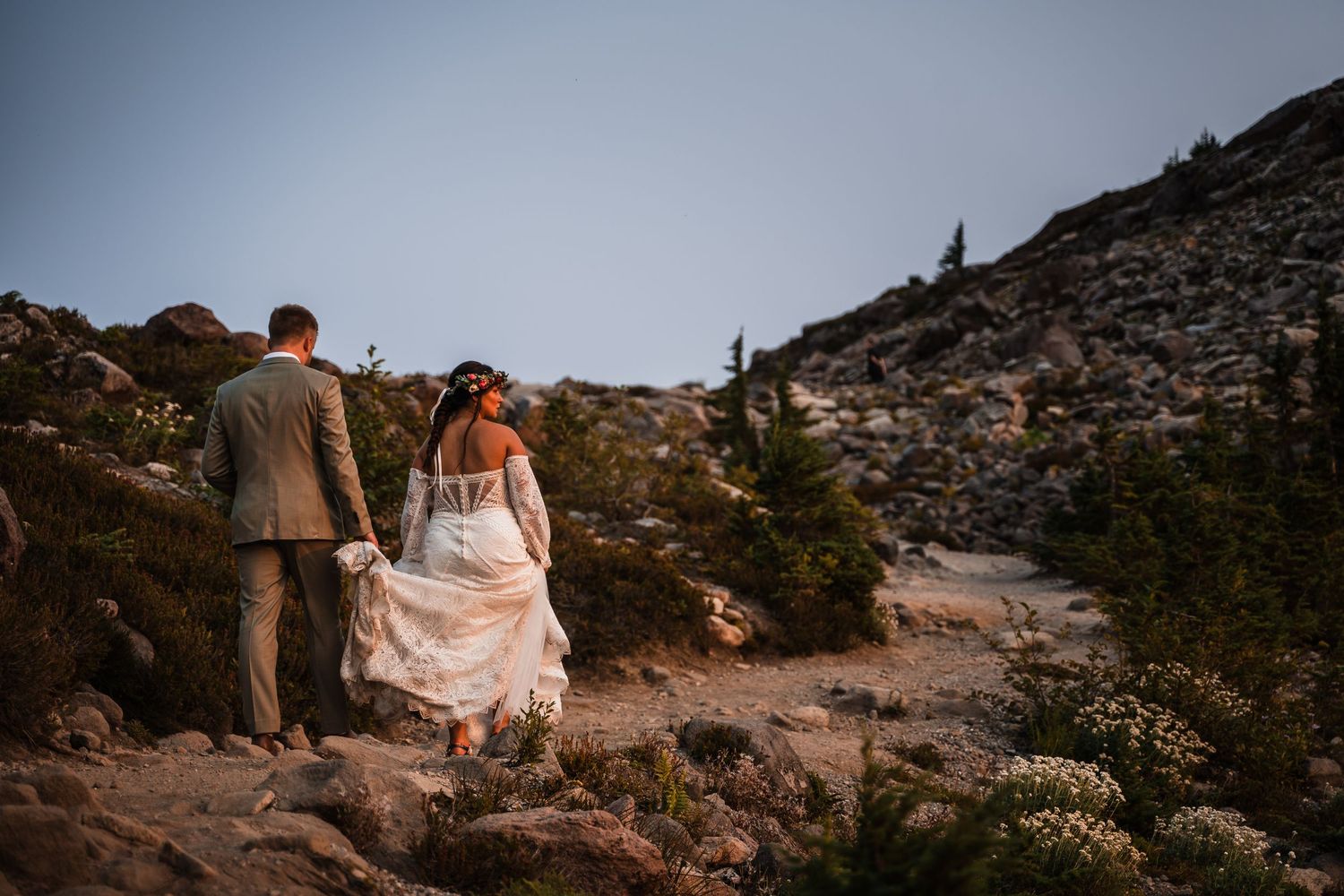 Dramatic mountain vista with rocky terrain and hiking trails at sunset.