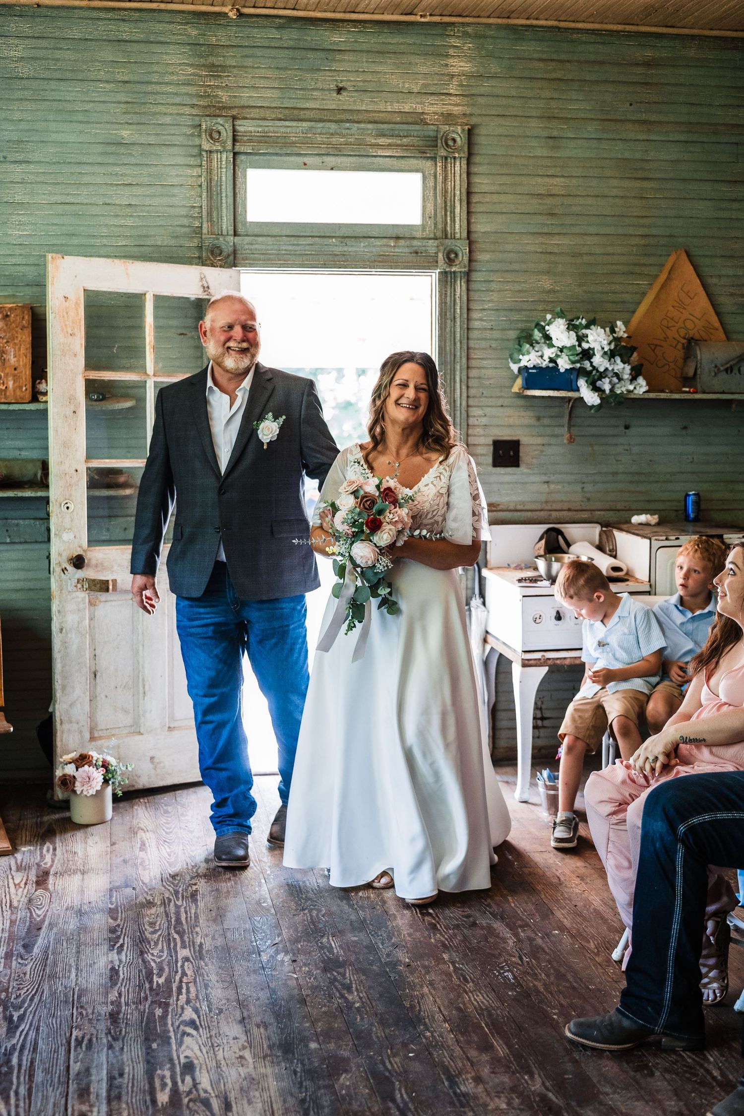 Wedding celebration inside rustic venue with wooden floors and vintage decor.