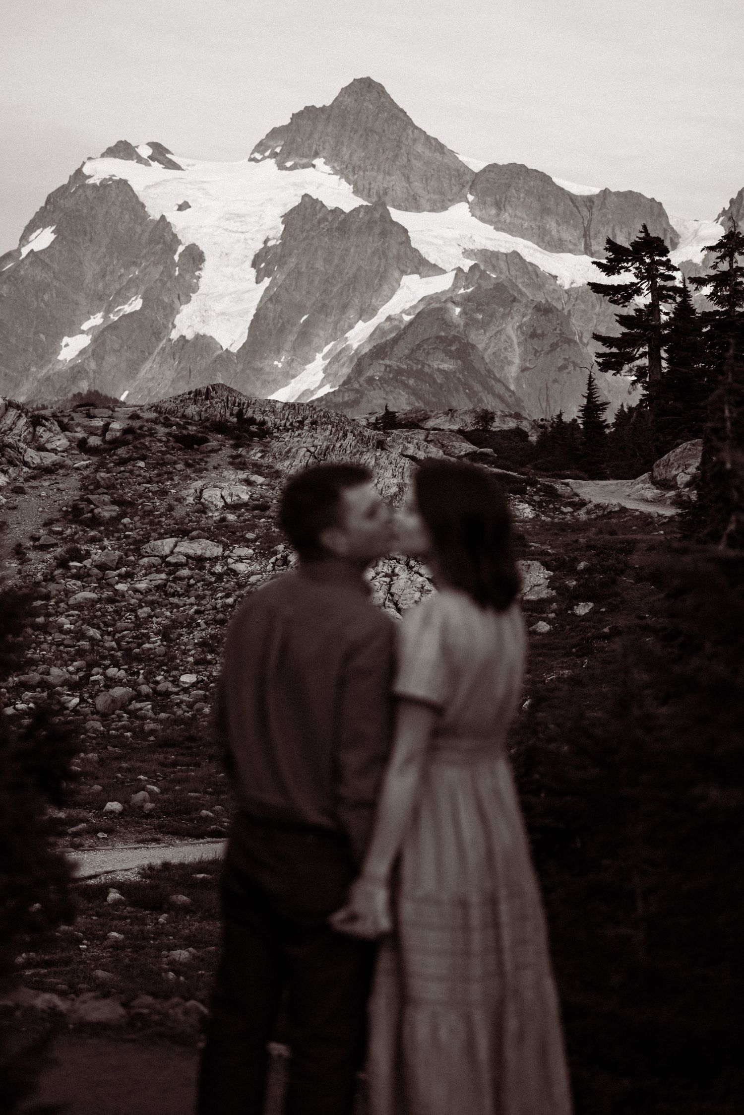 Vintage black and white photo series showing silhouettes of people against a dramatic mountain landscape backdrop.