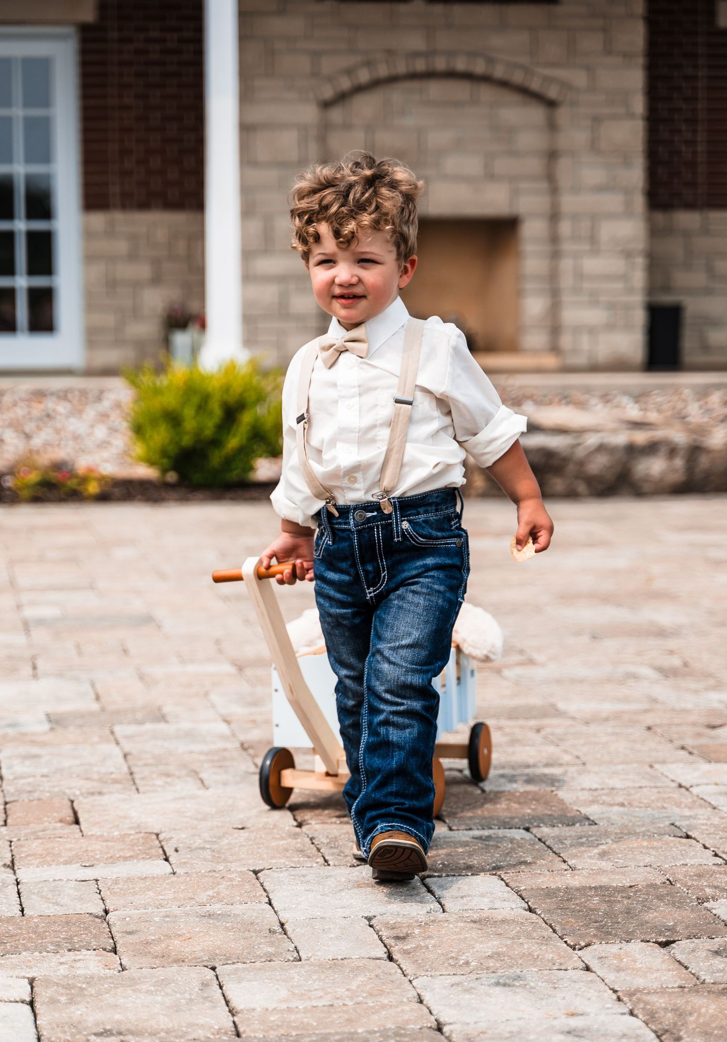 Child in jeans and white shirt running playfully across stone courtyard.