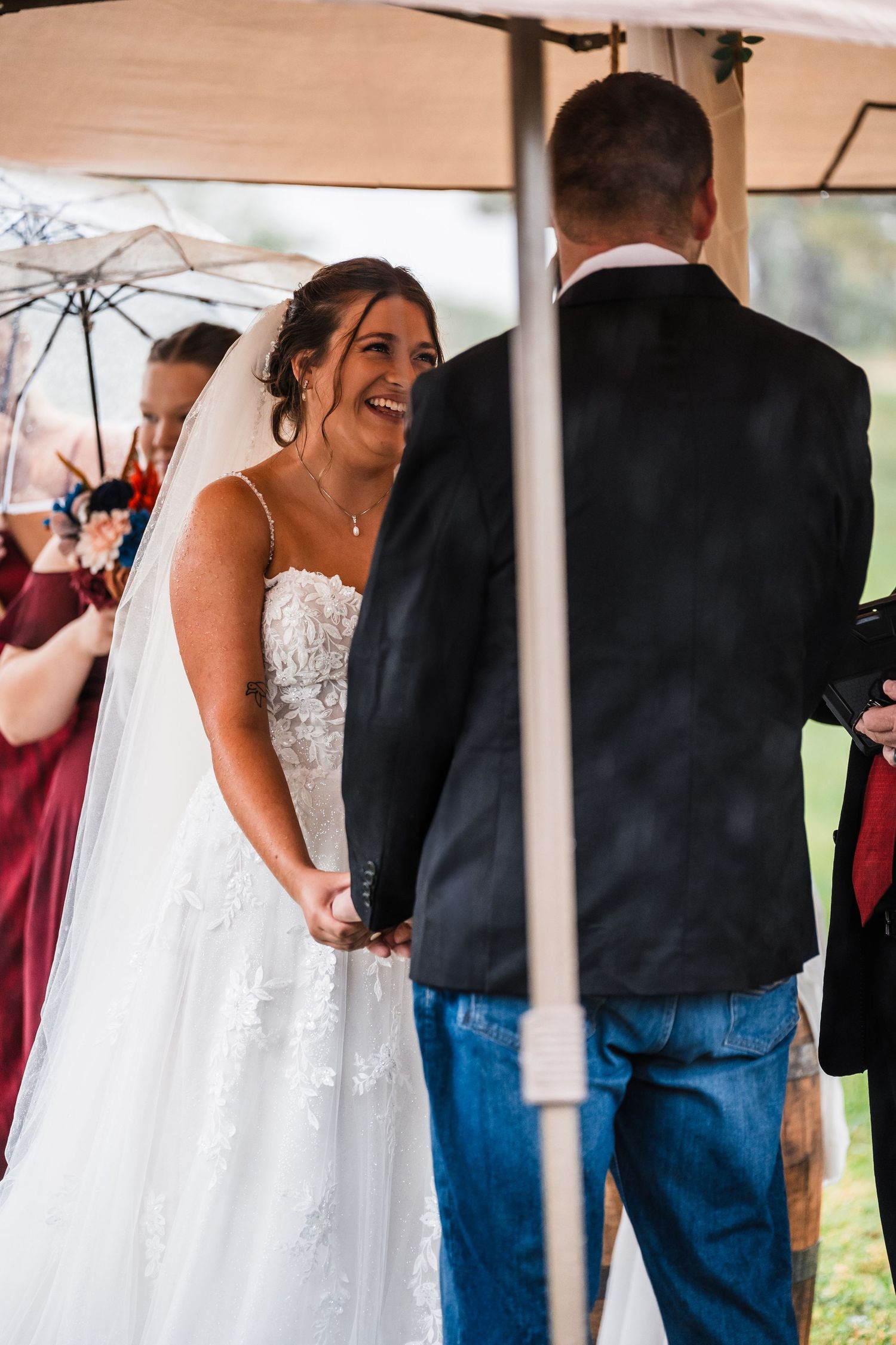 Candid wedding ceremony moments captured under a white tent with guests looking on.