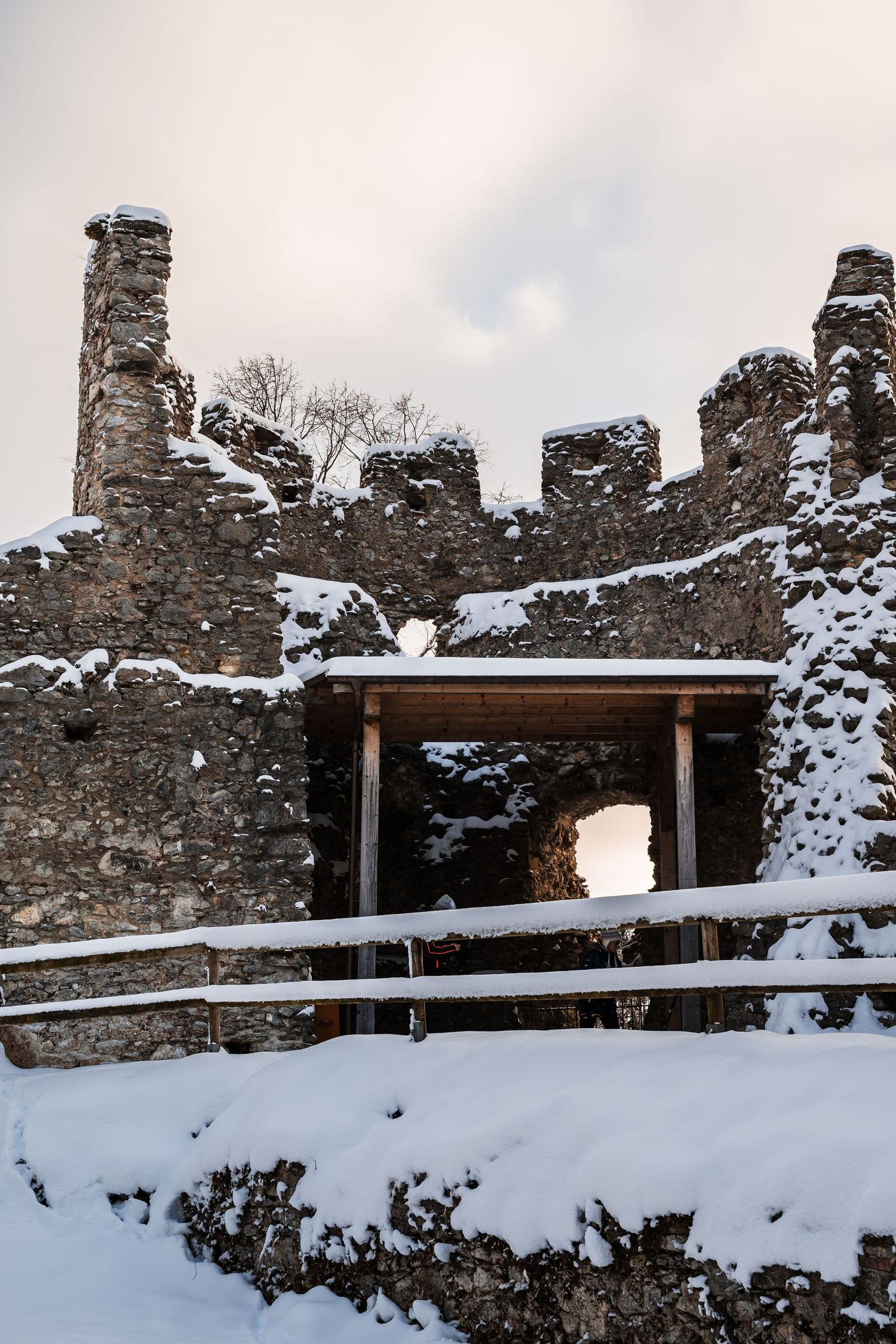 Snow-covered medieval fortress walls with wooden viewing platforms along the ramparts.
