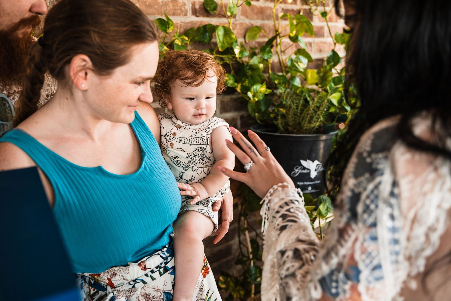 People gather outdoors in a garden setting while interacting and sharing a warm moment together.