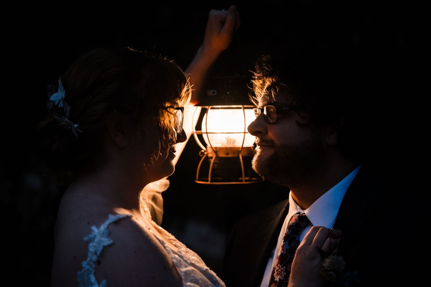 Romantic silhouette portrait with lantern light creating dramatic mood.
