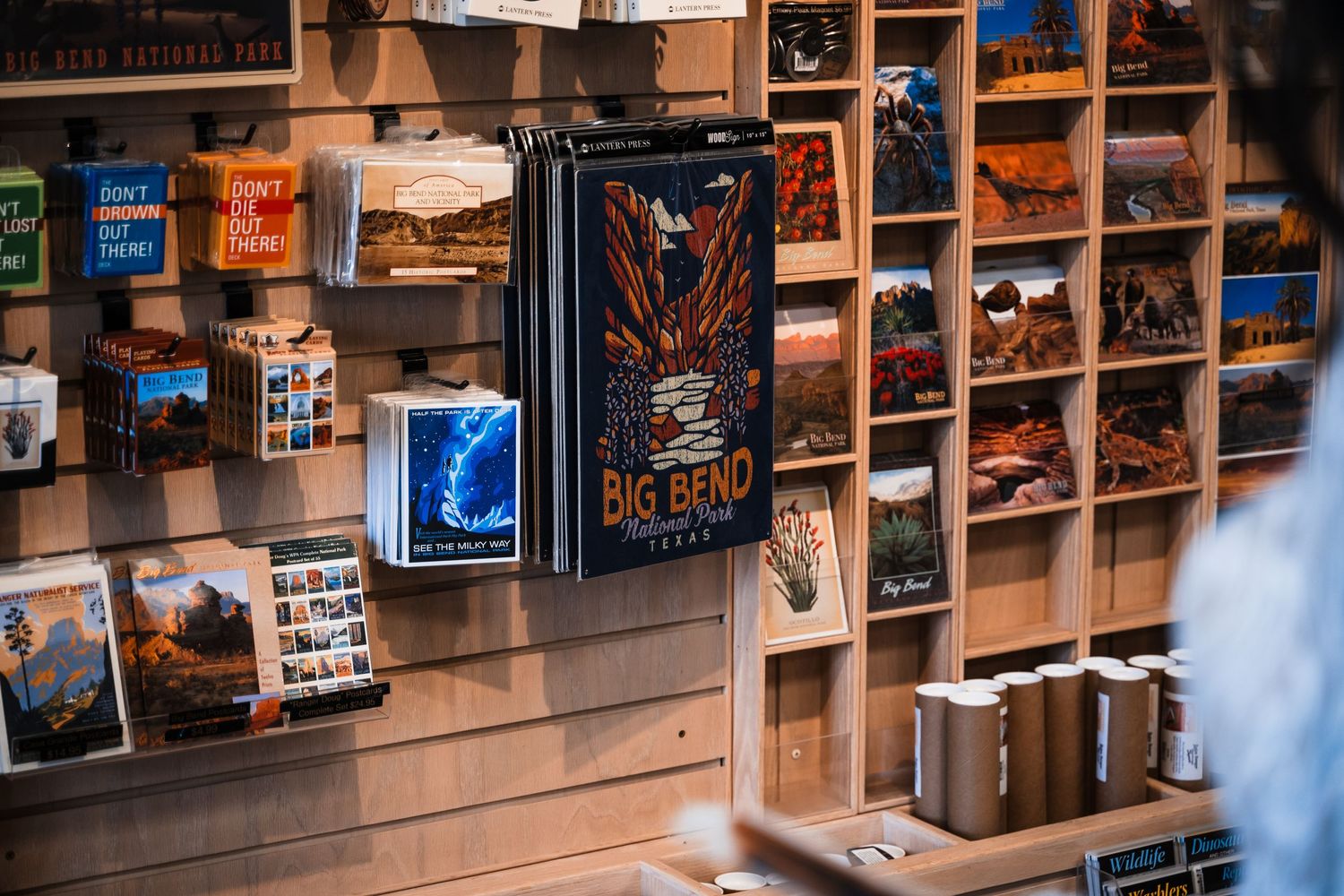 Wall display of vintage posters and postcards in a rustic store setting.