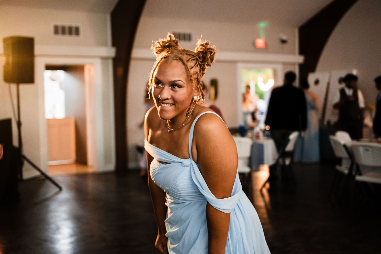 Dancing guest in a light blue dress enjoying a celebration on the dance floor.