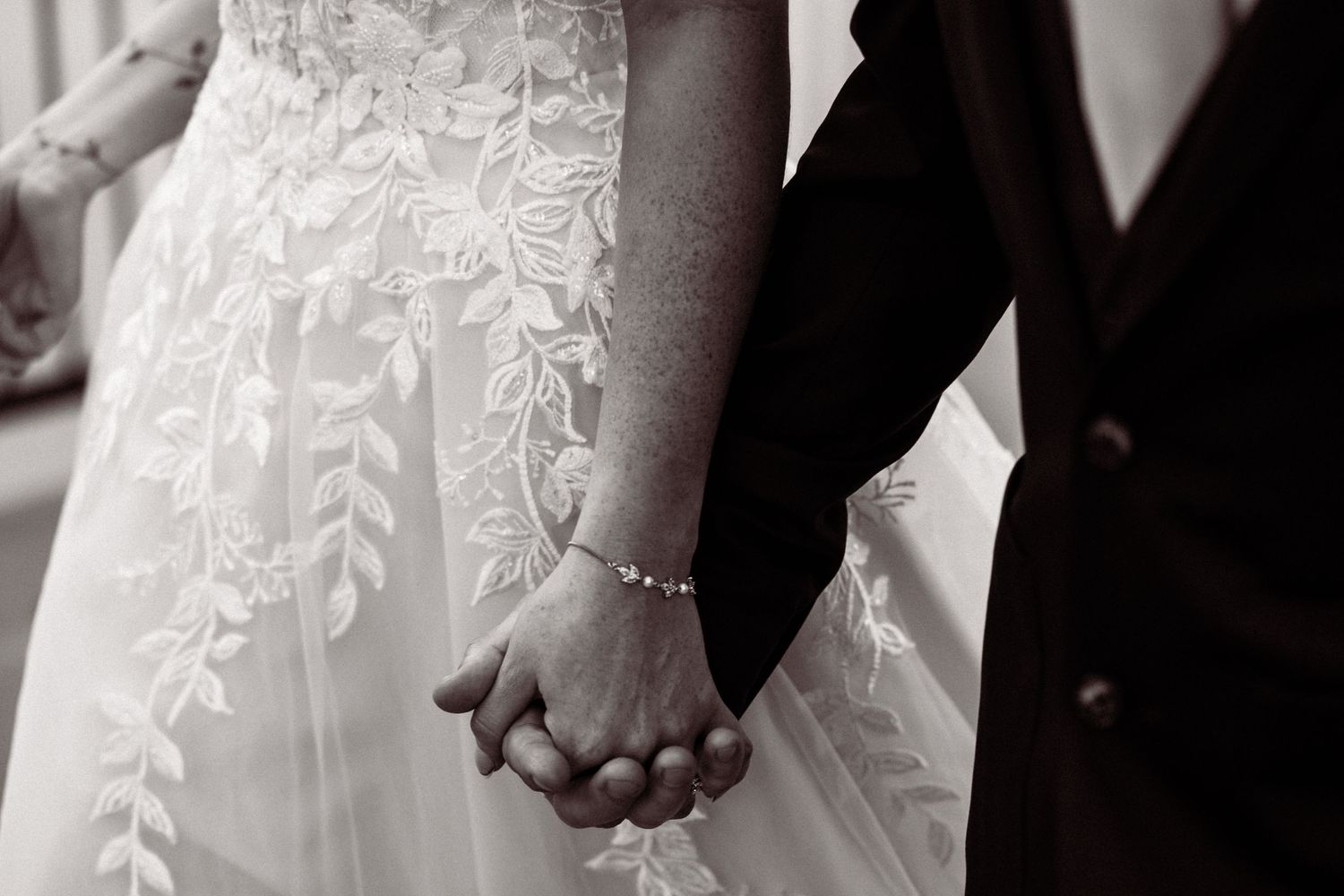 Detail shots of white lace wedding dress and formal black attire.