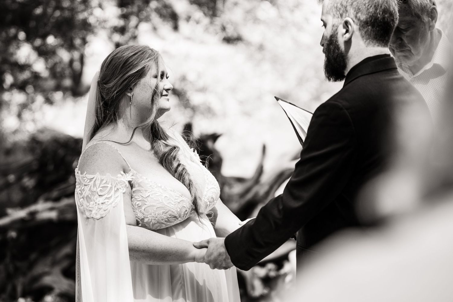 An emotional bride and groom exchange vows during an intimate outdoor wedding ceremony.