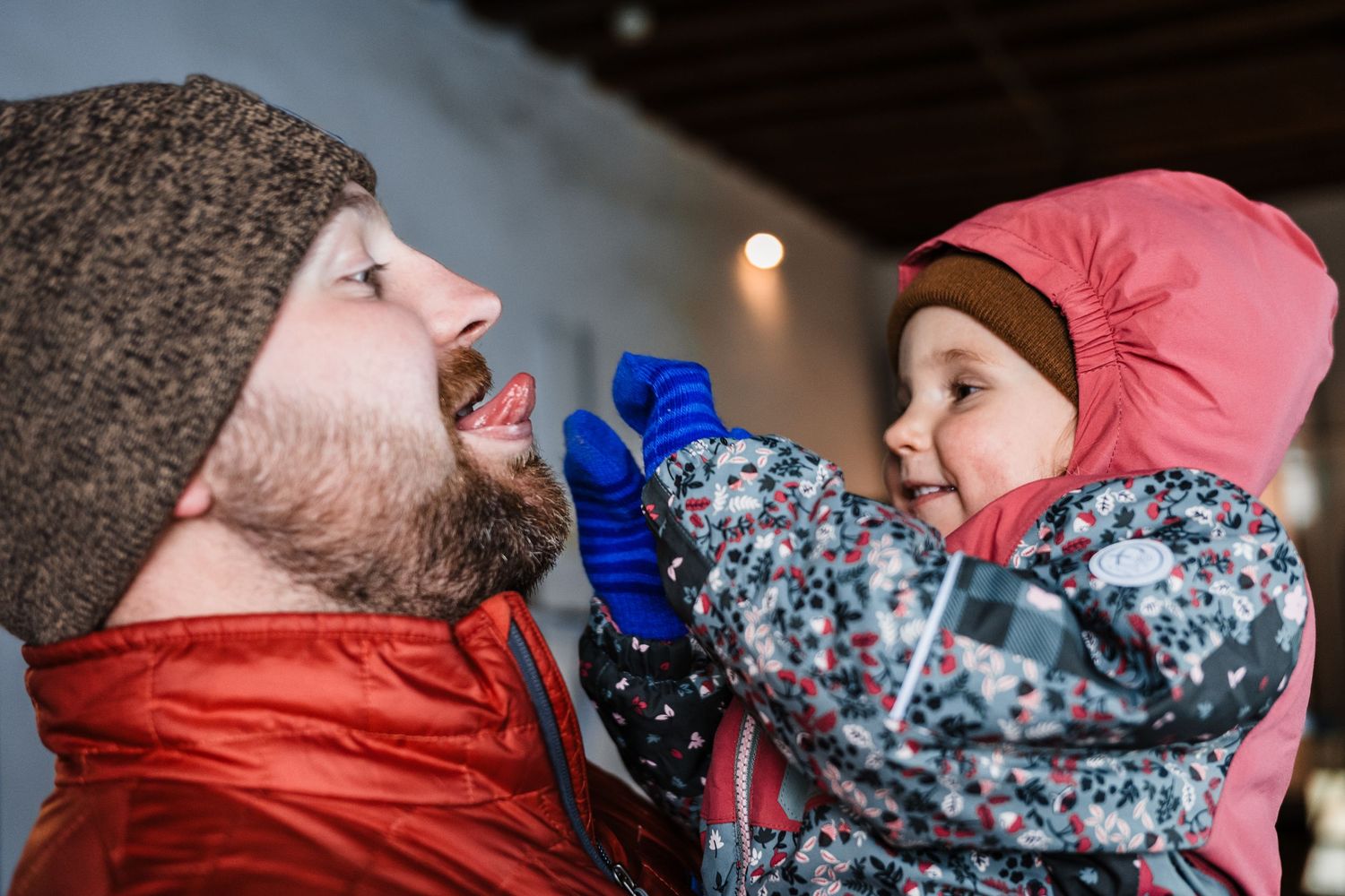 Two people sharing a tender winter moment outdoors in warm winter clothing.