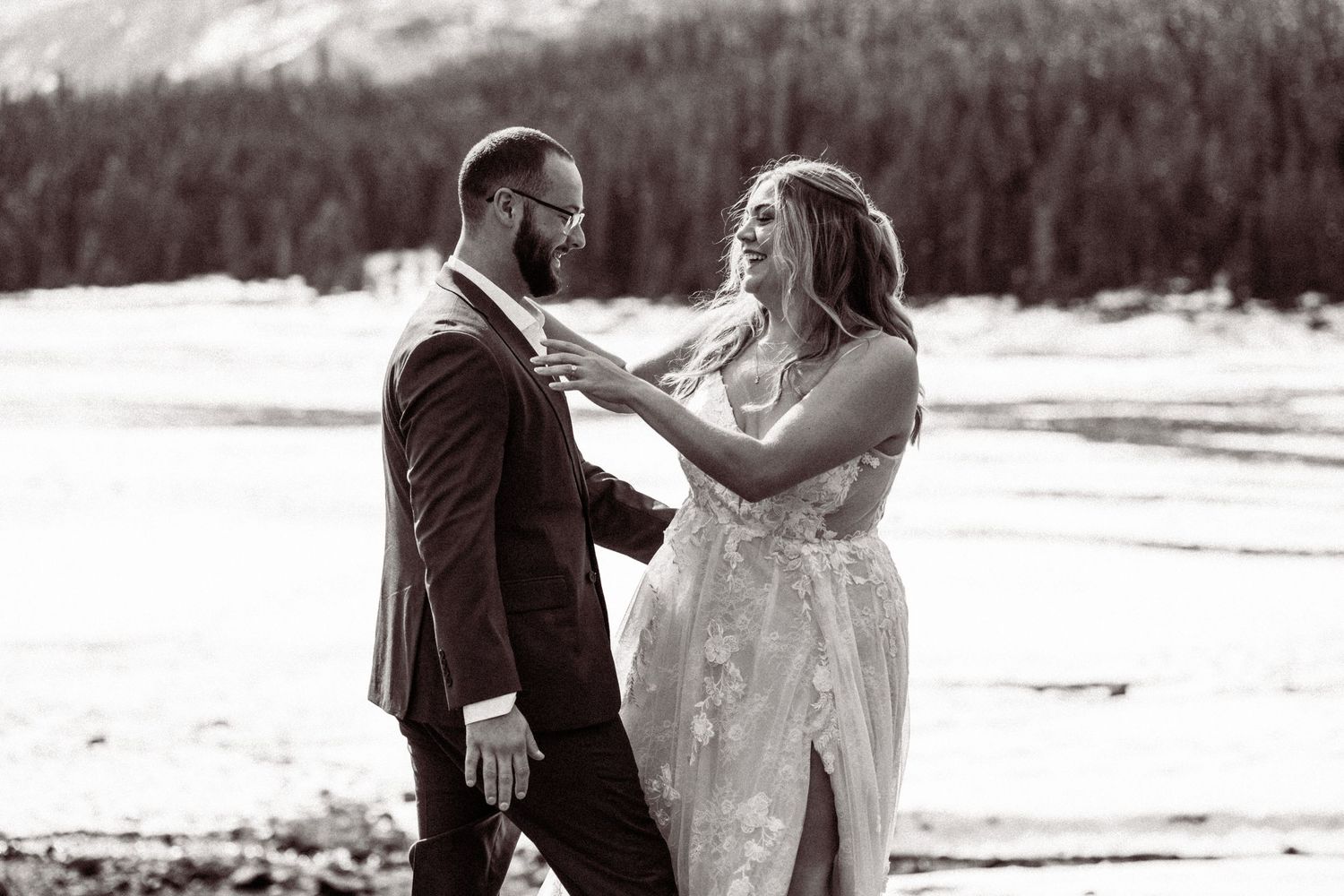 Black and white wedding portraits captured against a snowy mountain backdrop.