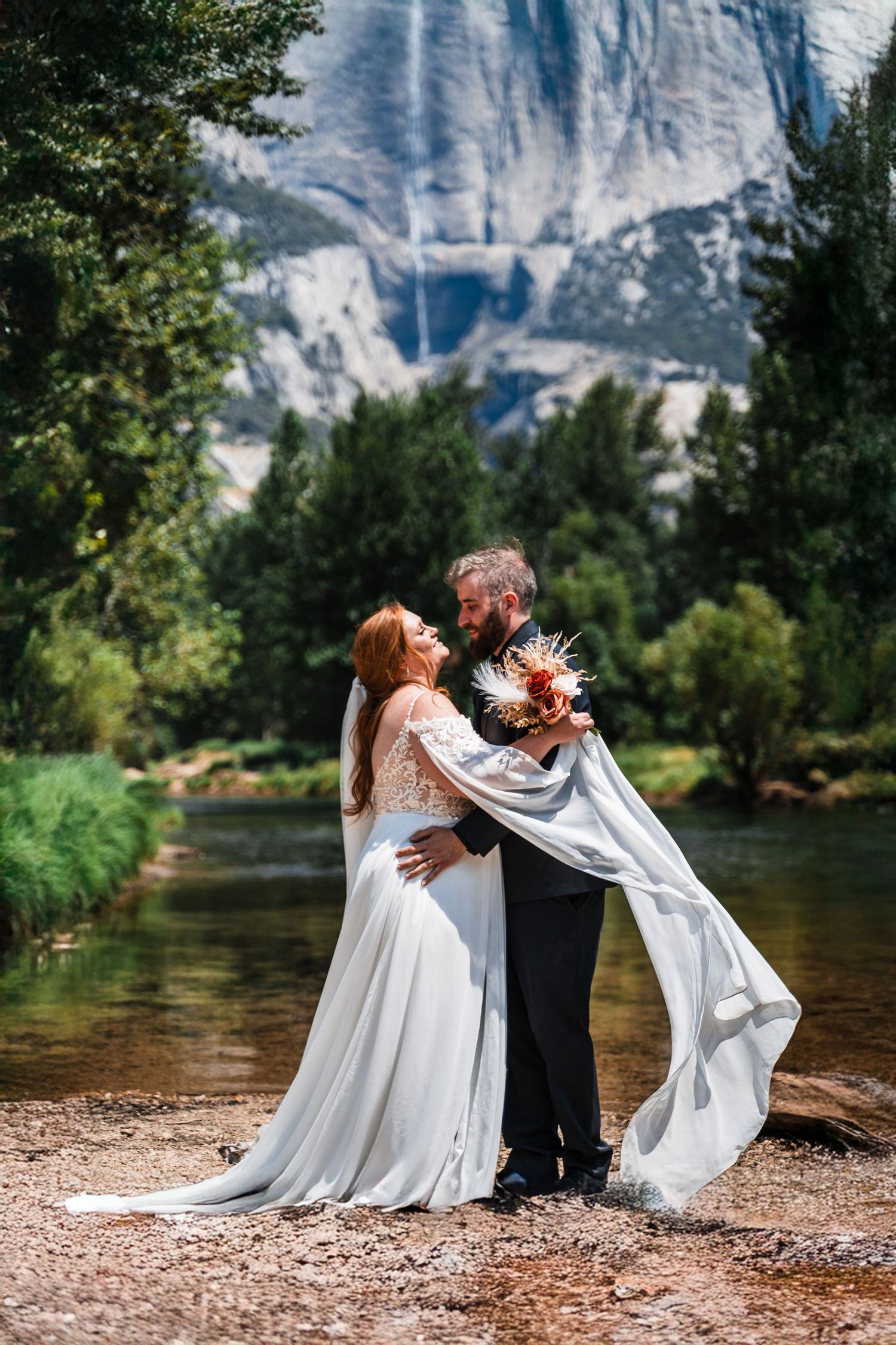 A romantic moment captured by a lake with mountains in the background at Yosemite National Park.