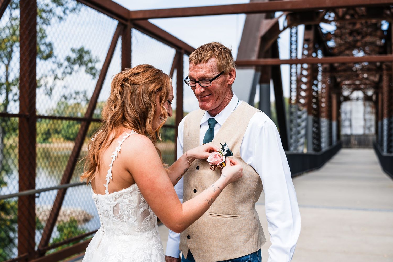 A couple shares a romantic moment on a rustic bridge during their wedding day.