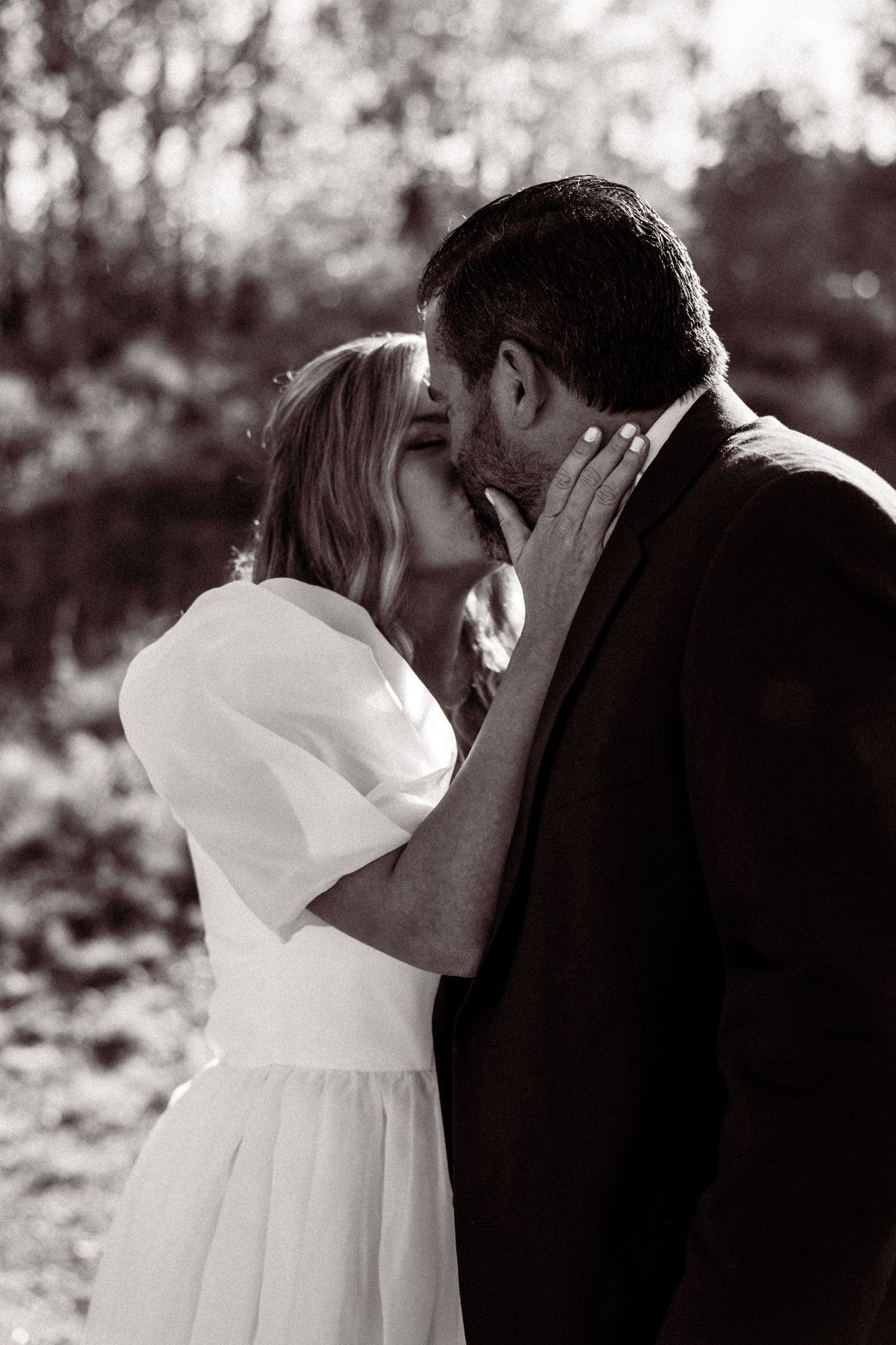 A romantic black and white wedding photo sequence showing a couple sharing an intimate moment in nature.