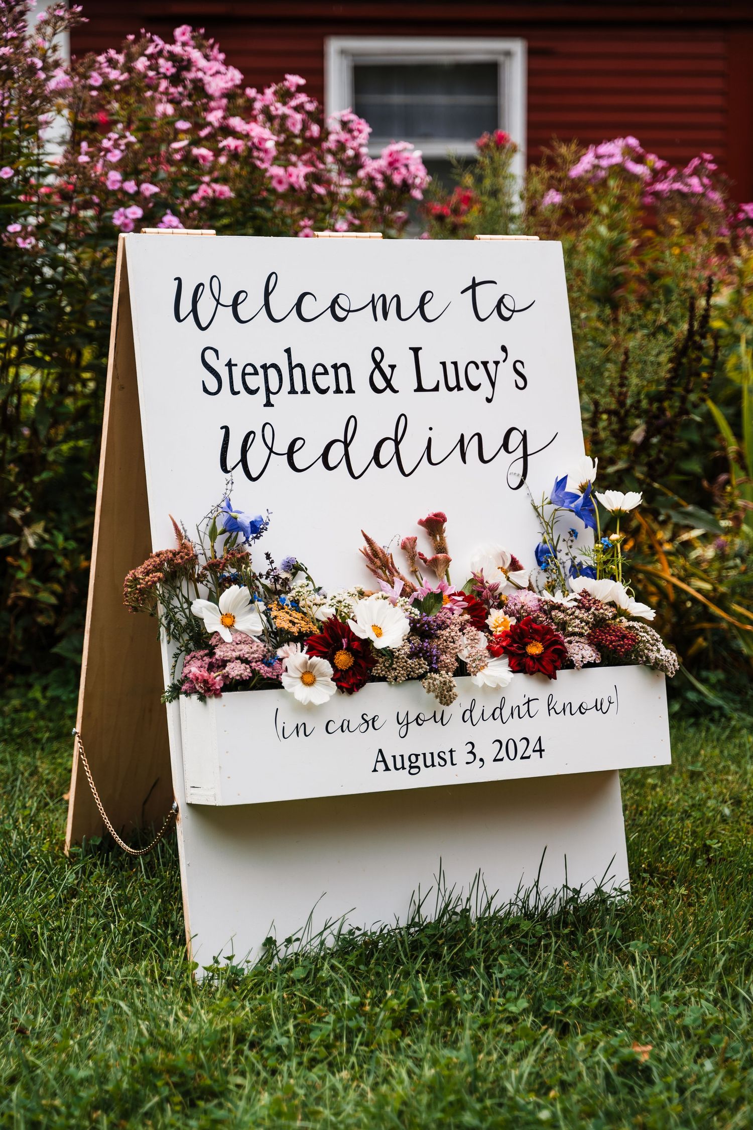 A decorative wedding welcome sign with floral arrangements announces Stephen and Lucy's celebration.