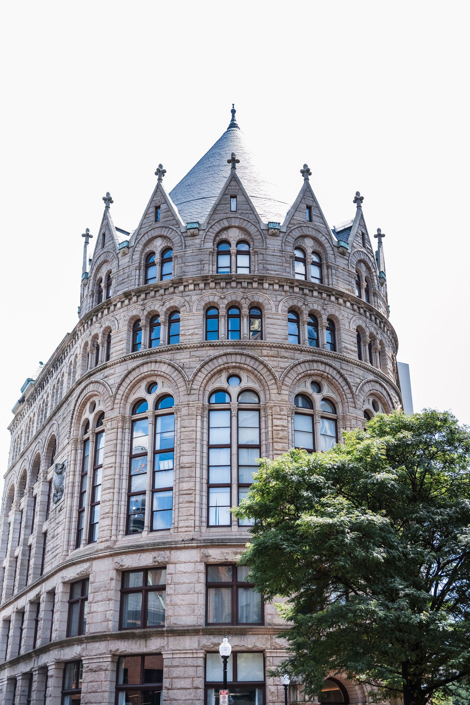 Gothic architecture detail of a historic stone building with ornate circular turret and arched windows in downtown Boston.