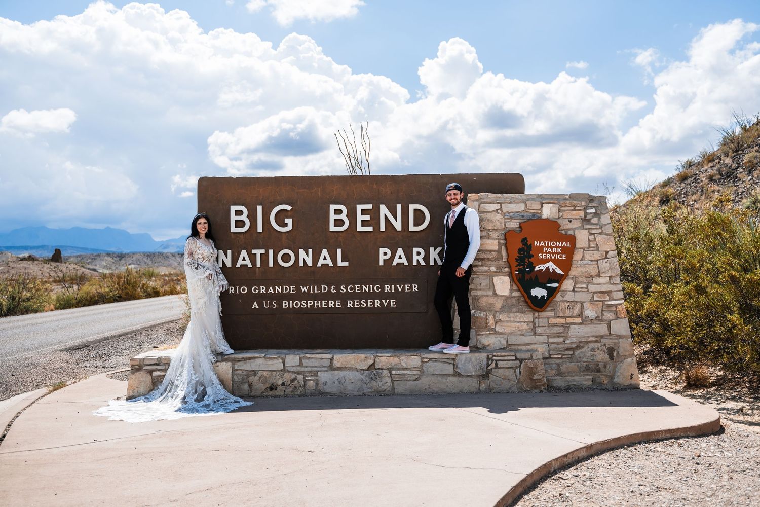 Wedding dress flowing in front of Big Bend National Park entrance sign.