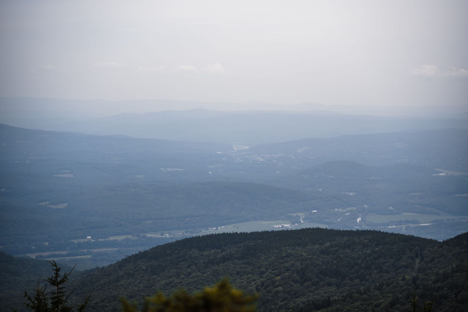 Misty mountain landscape shows layered ridges fading into the distant horizon.