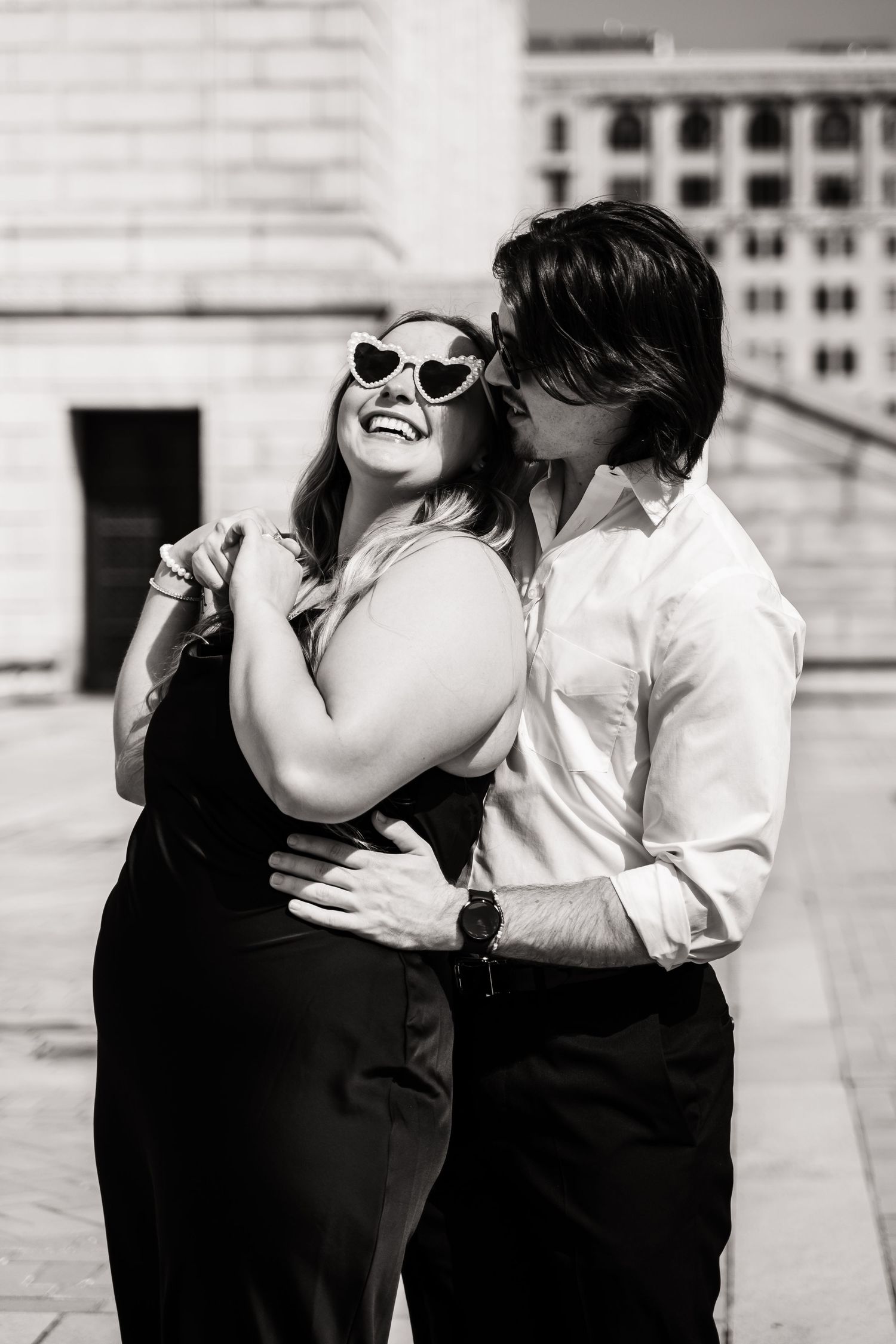 A romantic black and white photo series showing a couple embracing and sharing tender moments together.