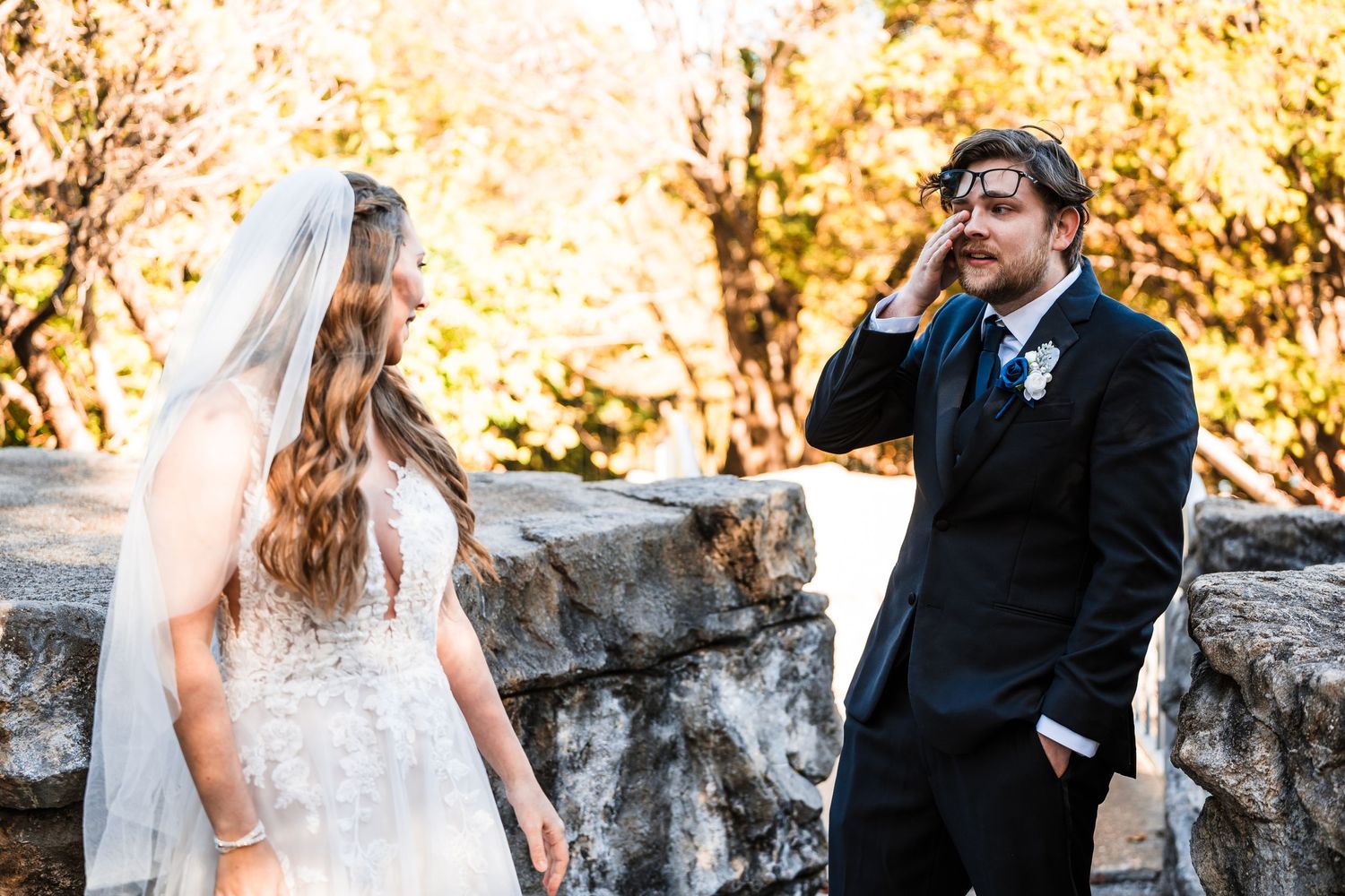 Candid moment of bride and groom sharing emotional reaction during autumn wedding ceremony.