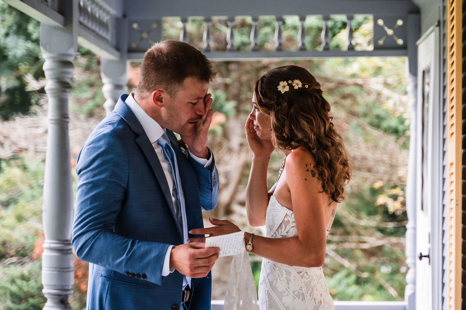 Emotional moment between couple exchanging vows on a covered porch.