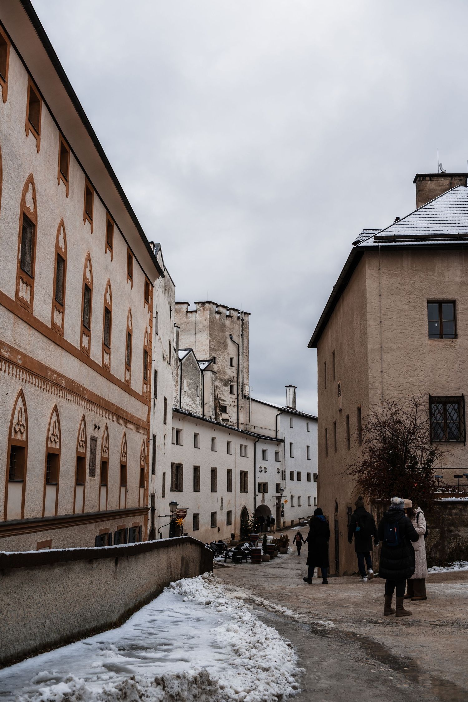 Long corridor of a historic building with snow-covered walkway and cream-colored walls.