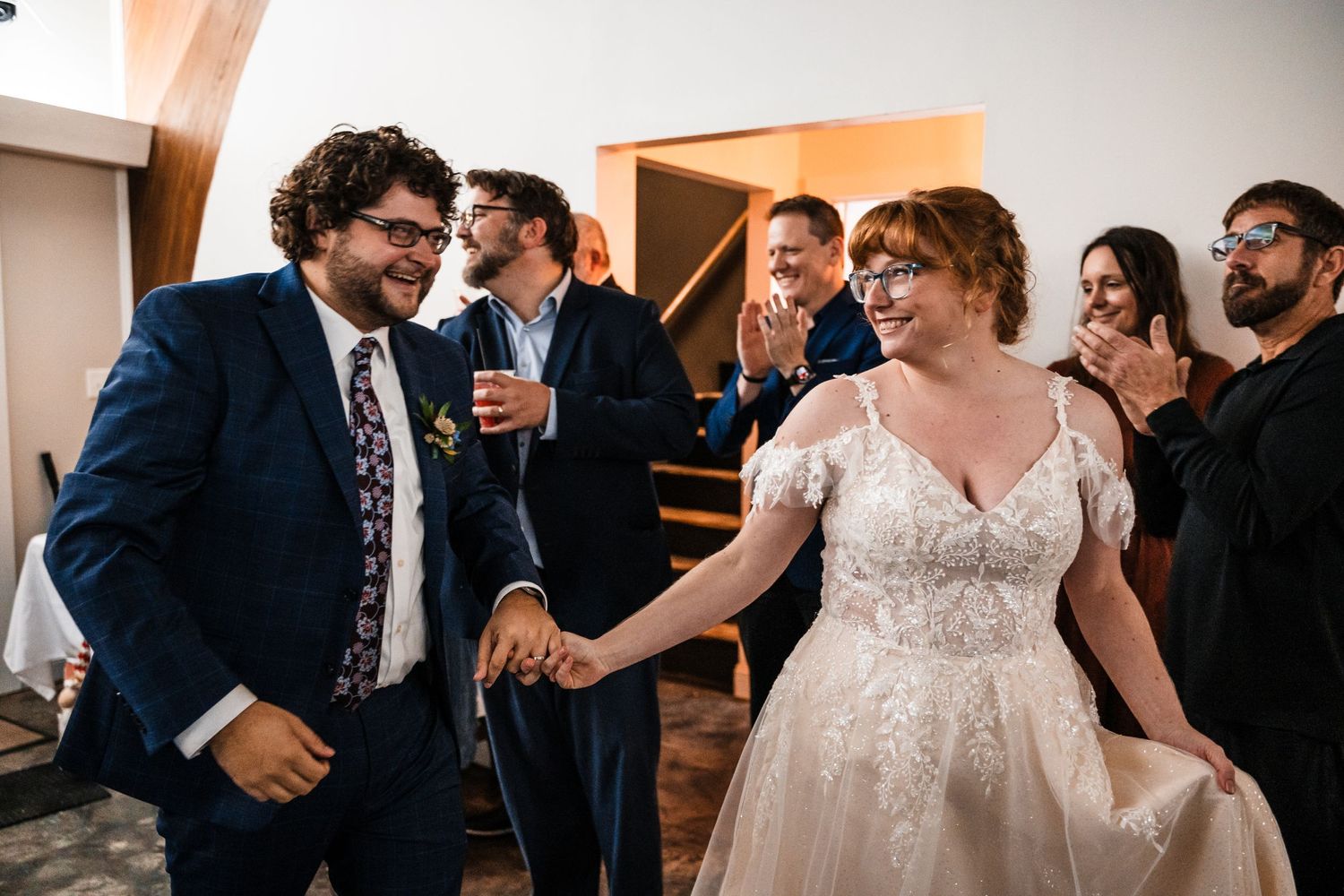 Joyful couple dancing and laughing during wedding reception celebrations.