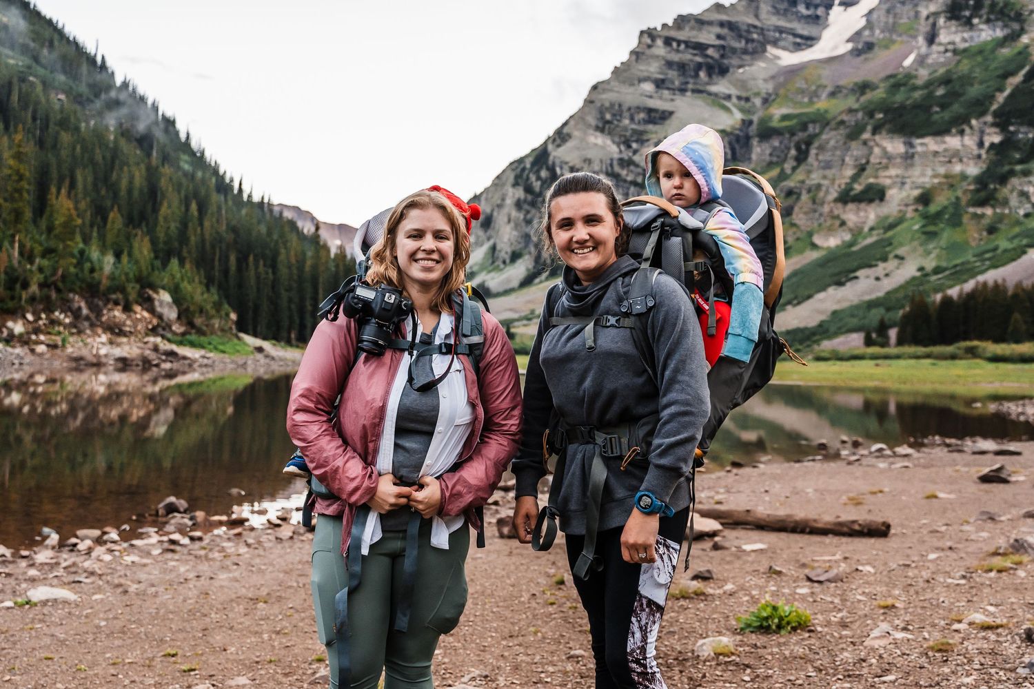 Family enjoying an outdoor adventure at a mountain lake surrounded by rocky terrain.