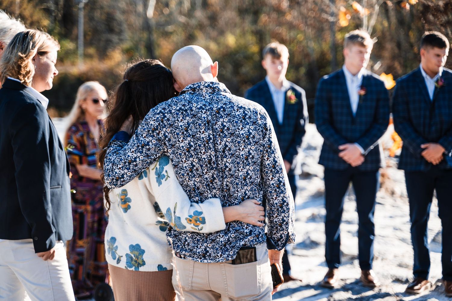 Wedding guests and wedding party gathered outdoors in winter for intimate ceremony.