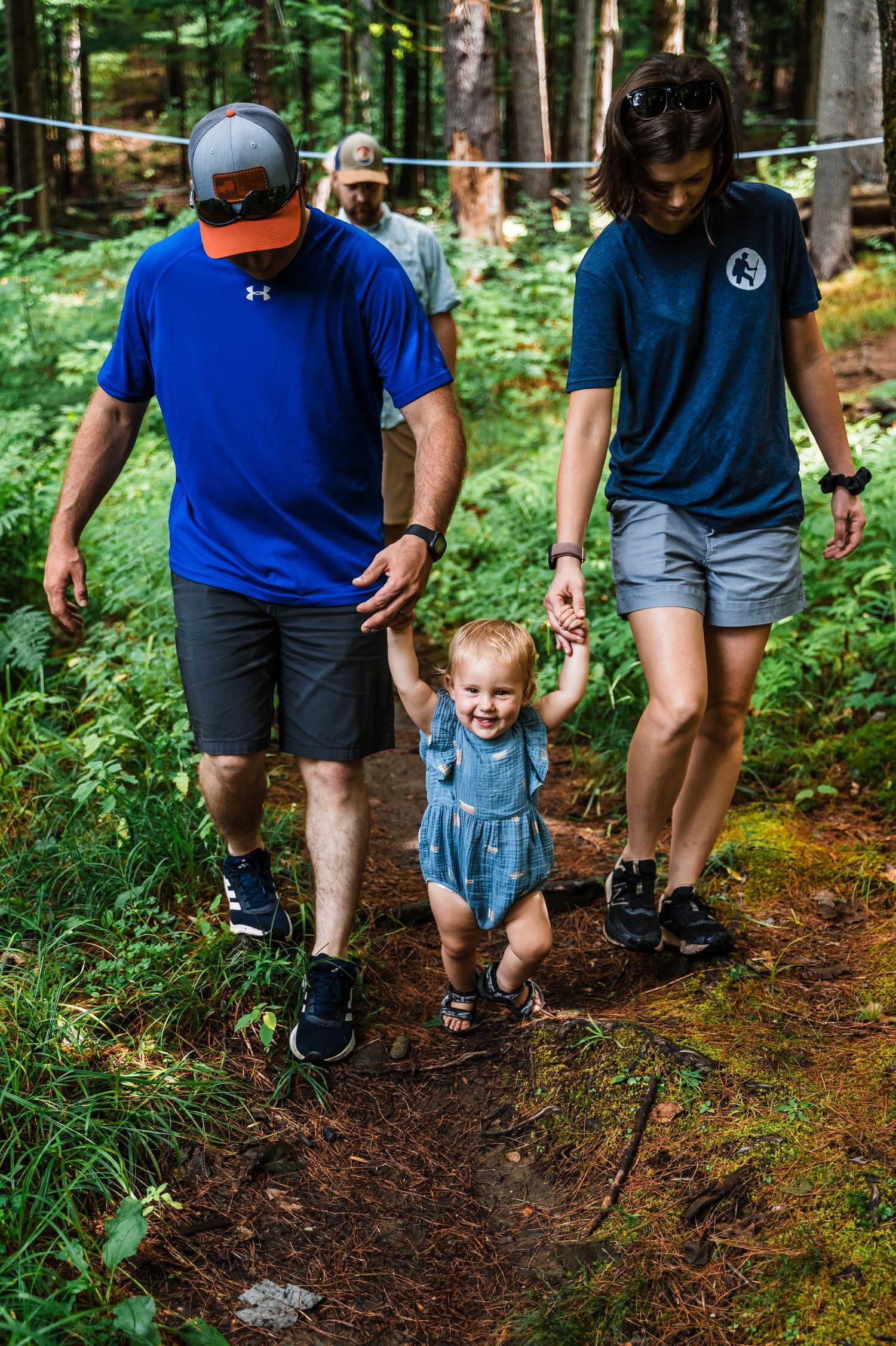 A group walks together on a wooded trail during an outdoor adventure in the forest.
