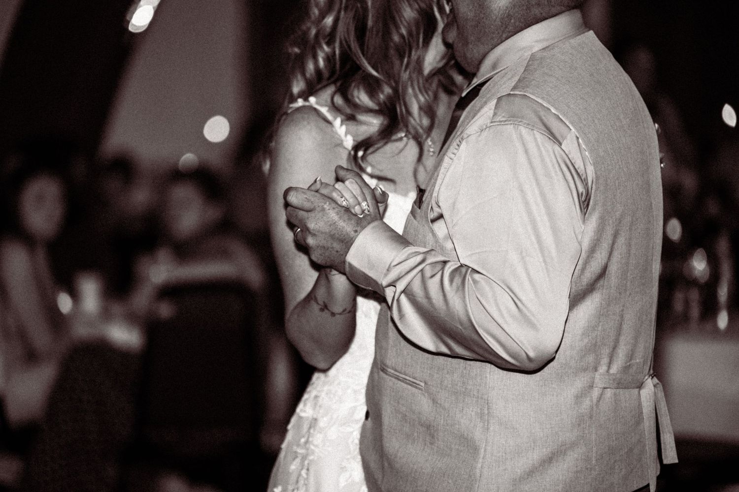Silhouettes of couples dancing together at an evening reception.