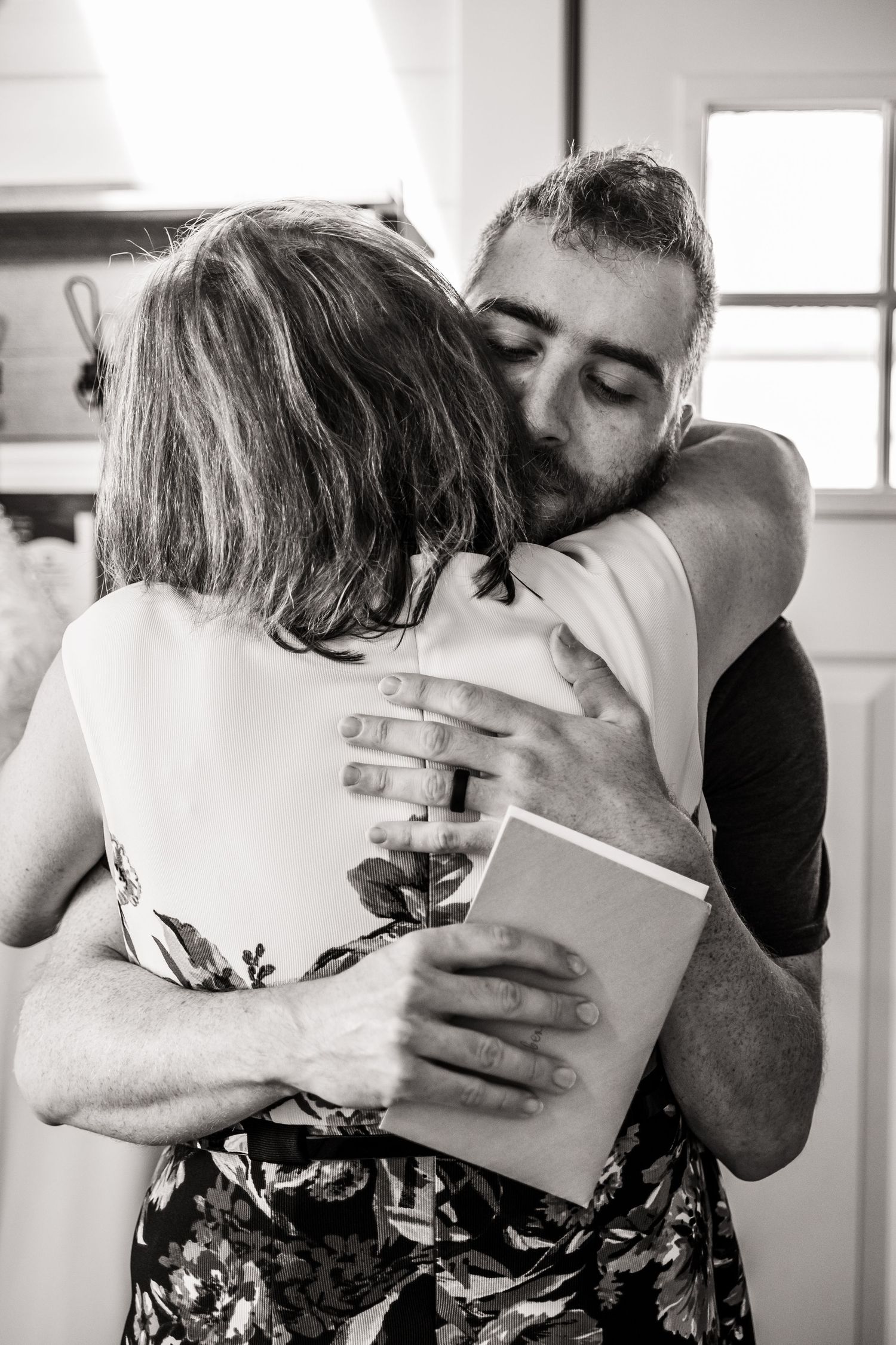 A sequence of black and white photographs showing people embracing and hugging in tender moments.
