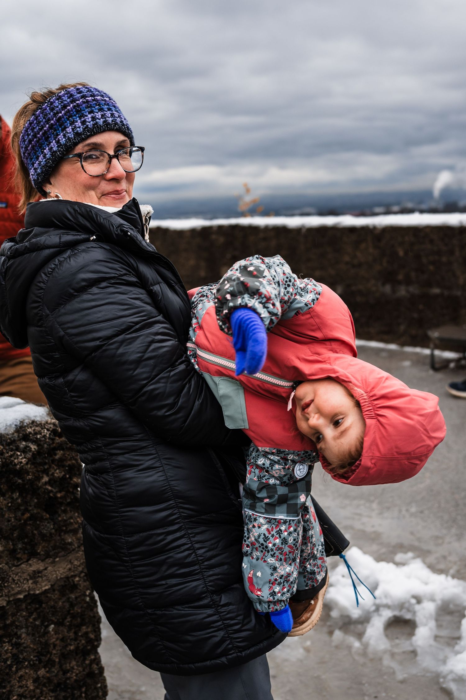Two people sharing a playful moment against a snowy mountain backdrop.