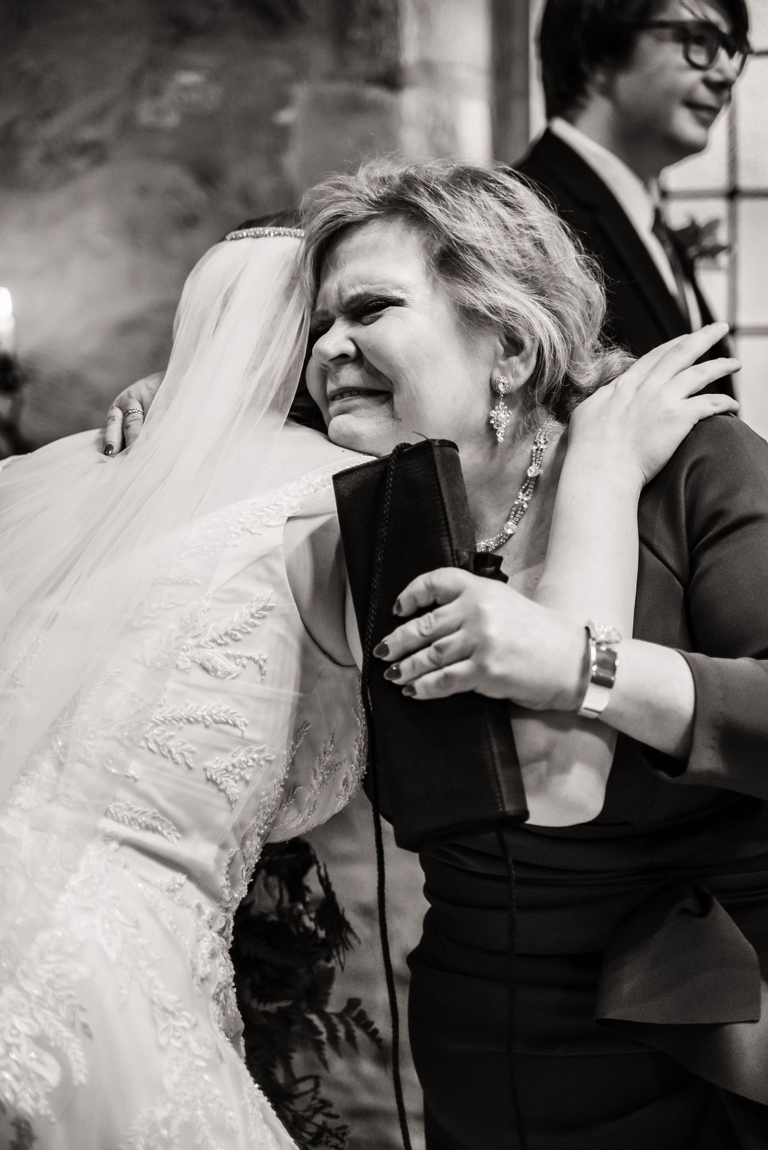An emotional embrace during a wedding reception captures candid joy and celebration.