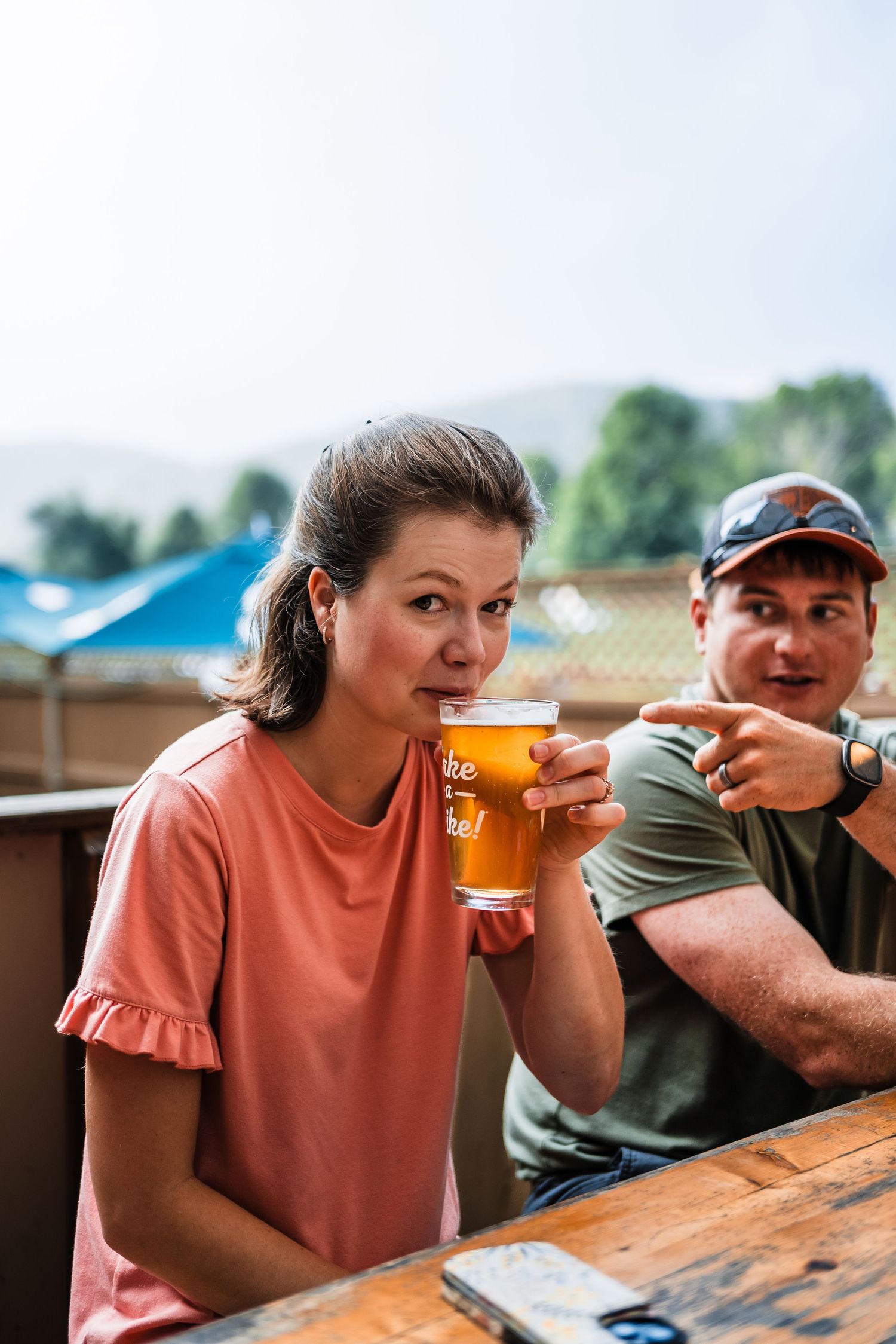 Two friends enjoying craft beers on an outdoor patio on a sunny afternoon.