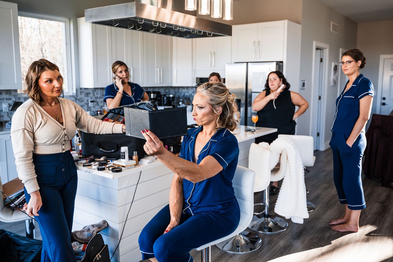 Modern open concept kitchen with people gathered for casual conversation and socializing.